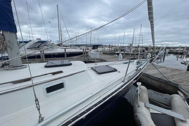 1978 Hinterhoeller Niagara 35 Classic sailboat docked at a marina under cloudy skies.