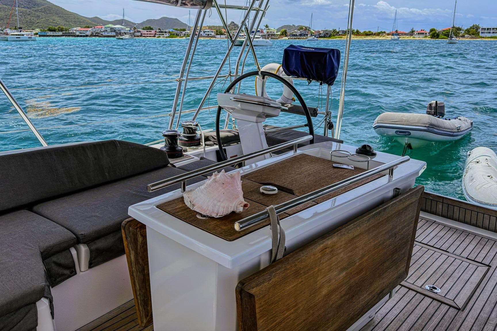 2020 Beneteau Oceanis 46.1 yacht cockpit with scenic ocean view and conch shell.