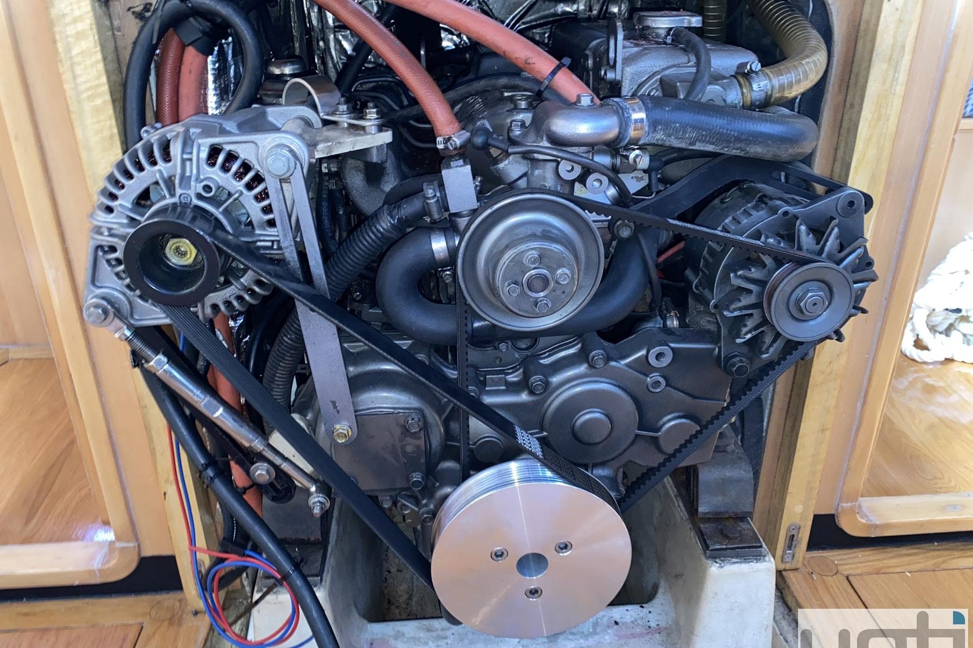 Engine of a 2012 Ker 50 sailboat, showcasing belts and components.