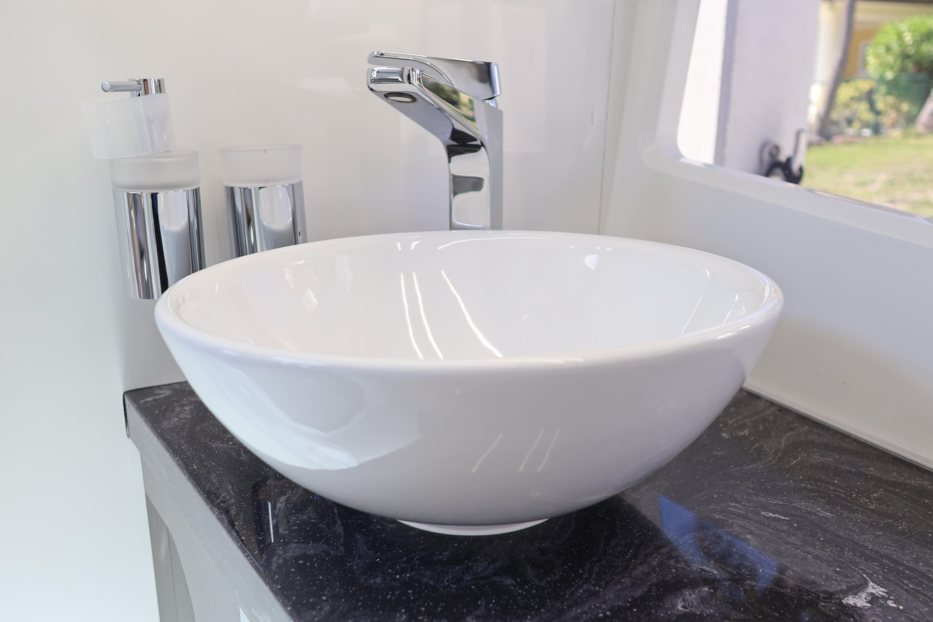 Modern white sink with chrome faucet on black countertop in 2024 Galeon 325 GTO.
