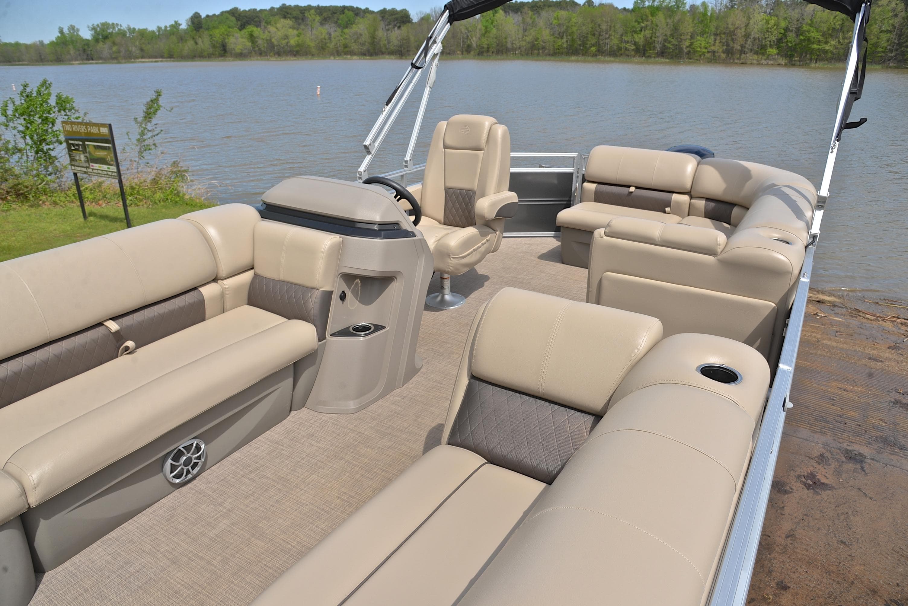 2024 Sun Tracker Party Barge 20 DLX pontoon boat with spacious seating on a serene lake.