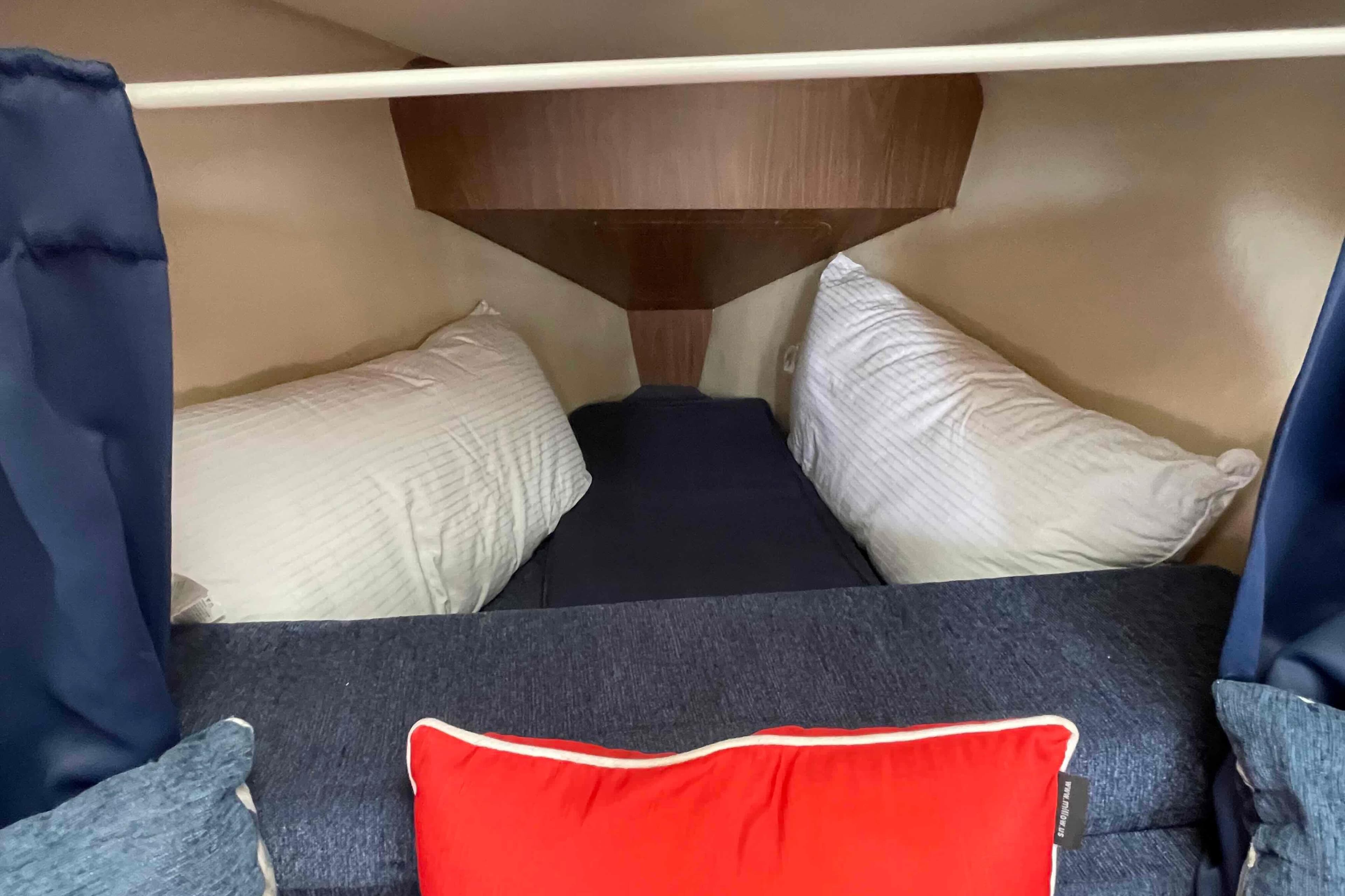 Cozy cabin interior of a 2006 Hunter 270 sailboat with pillows and cushions.