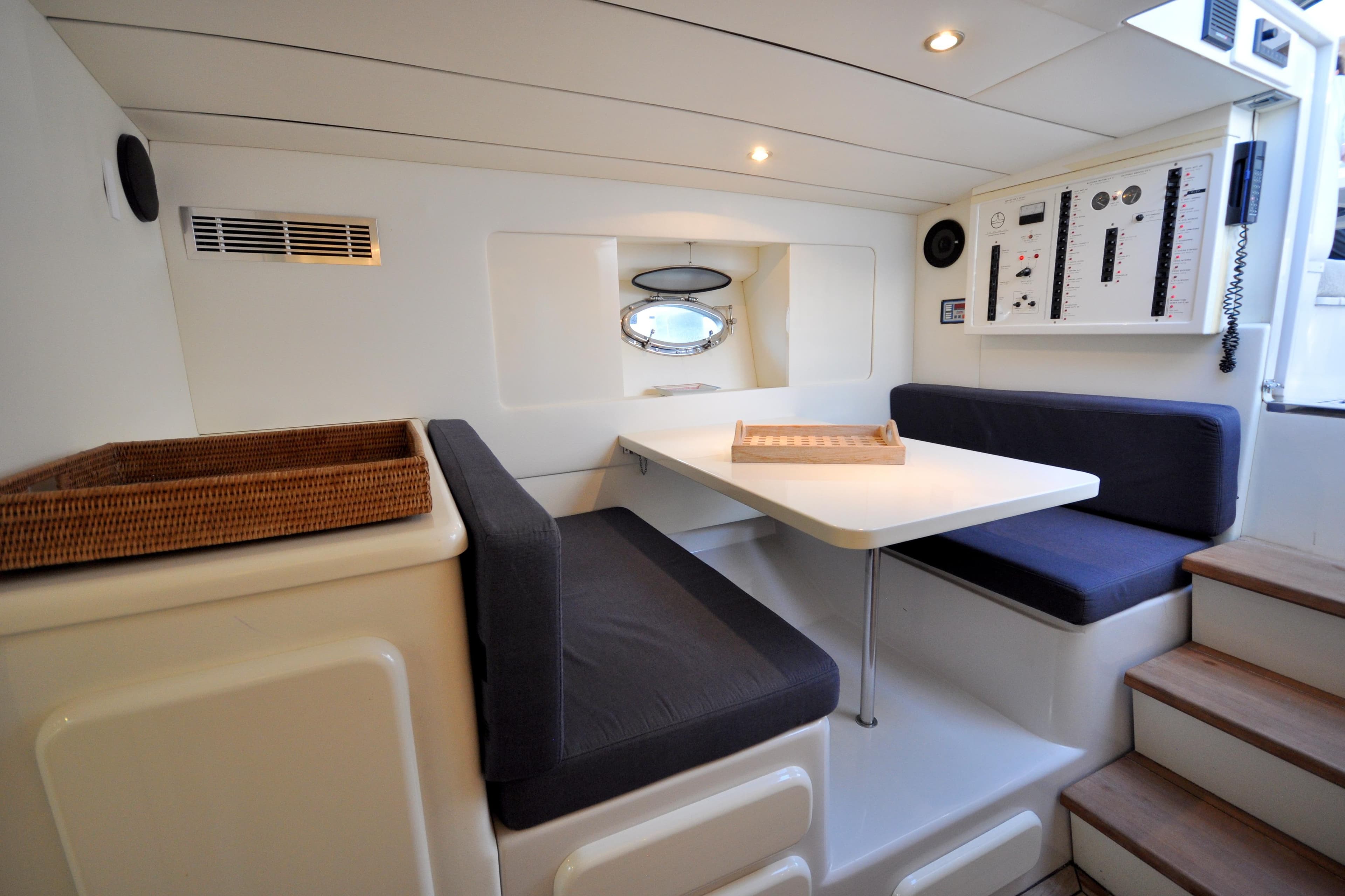 Interior of 1996 Itama 38 yacht with cozy seating and control panel.