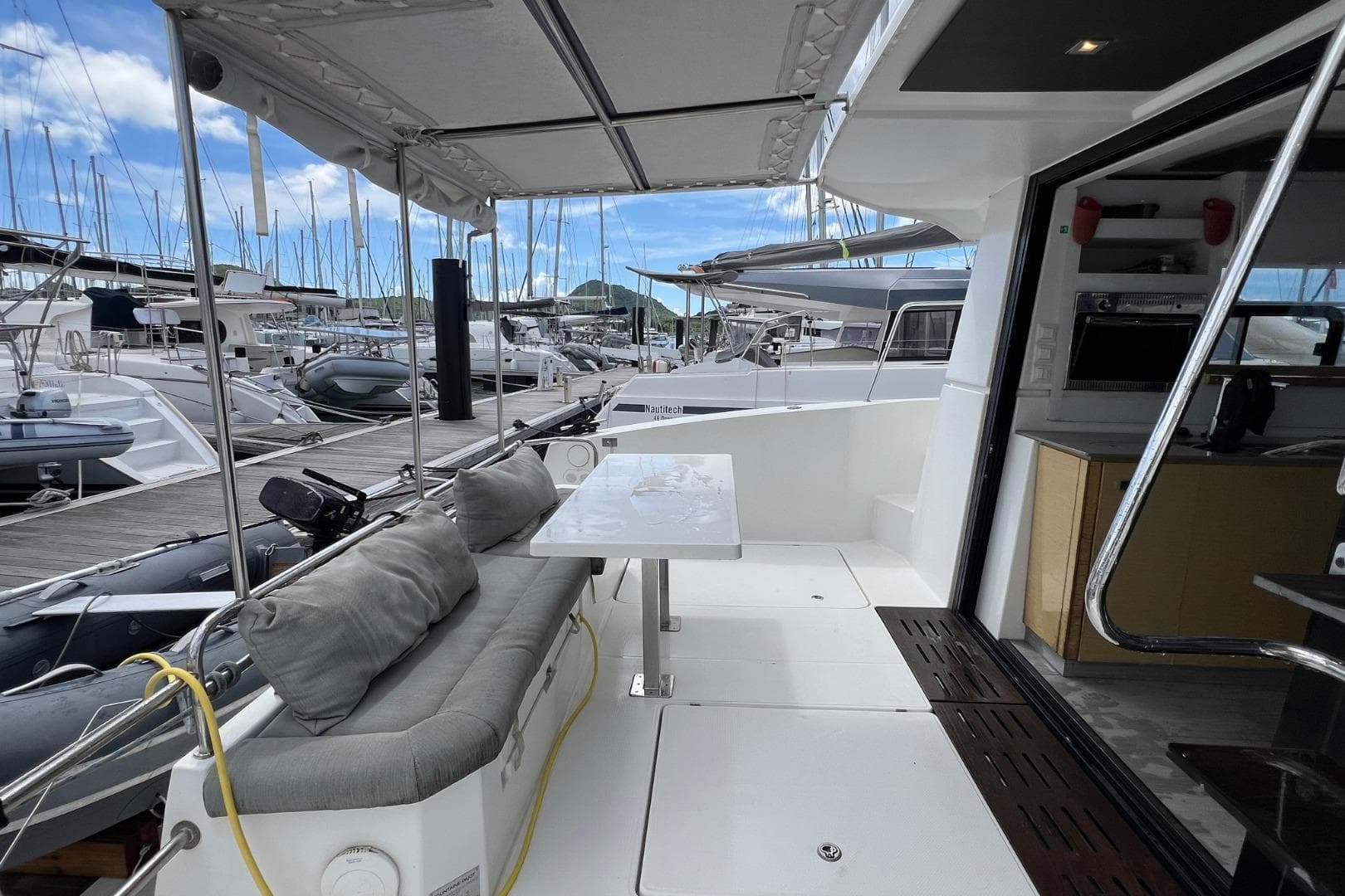 2018 Fountaine Pajot MY 37 yacht interior with seating and table, docked at marina.