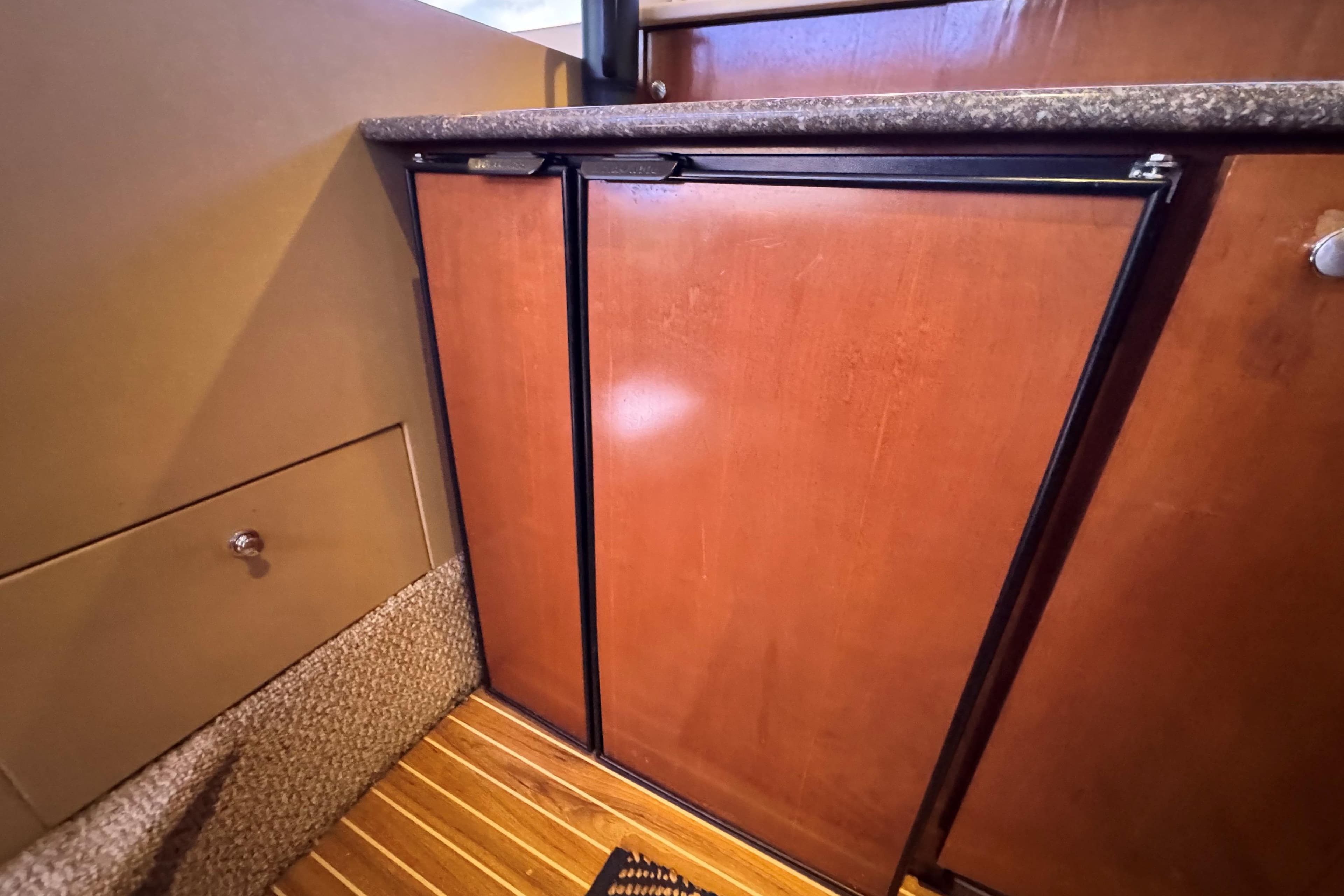 Wooden cabinetry in 2005 Meridian 368 Motoryacht interior, featuring sleek design and carpeted flooring.