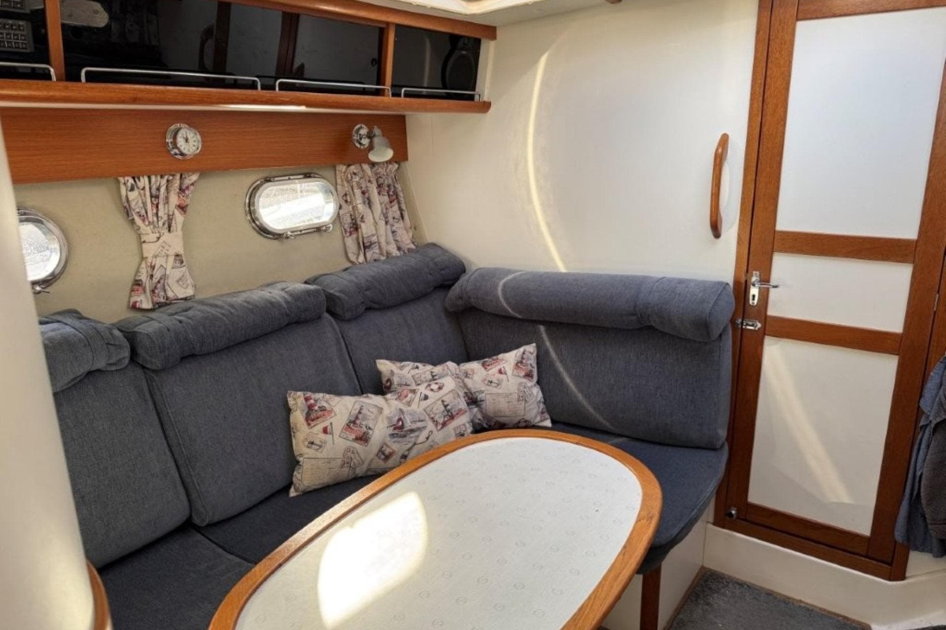 Interior of 1990 Nimbus 35 DC Fly boat with cozy seating and nautical decor.