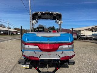 2024 MasterCraft NXT22 boat, blue and red, rear view on a trailer.
