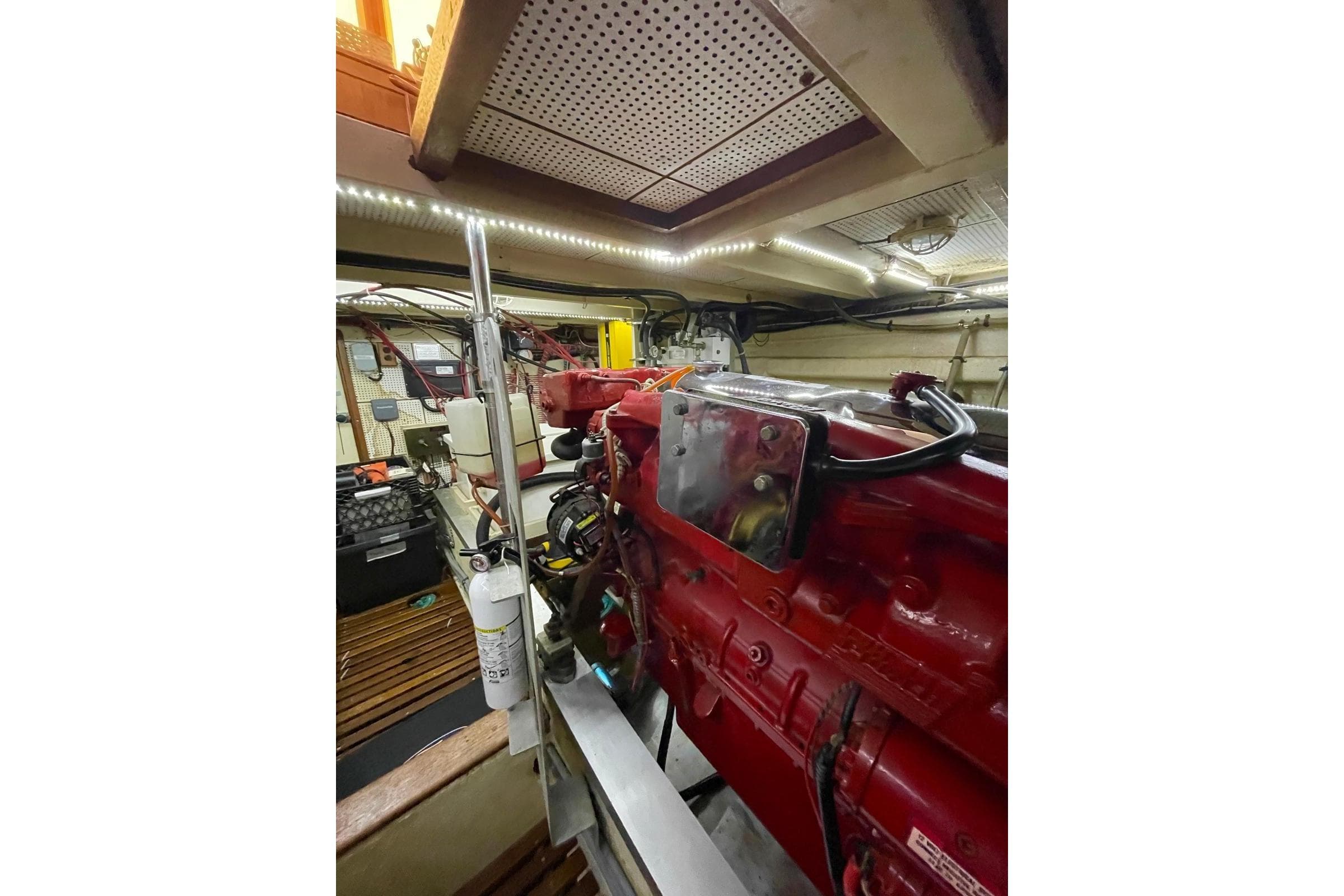 Engine room of 1986 Grand Banks 42 Classic yacht, featuring red machinery and organized layout.