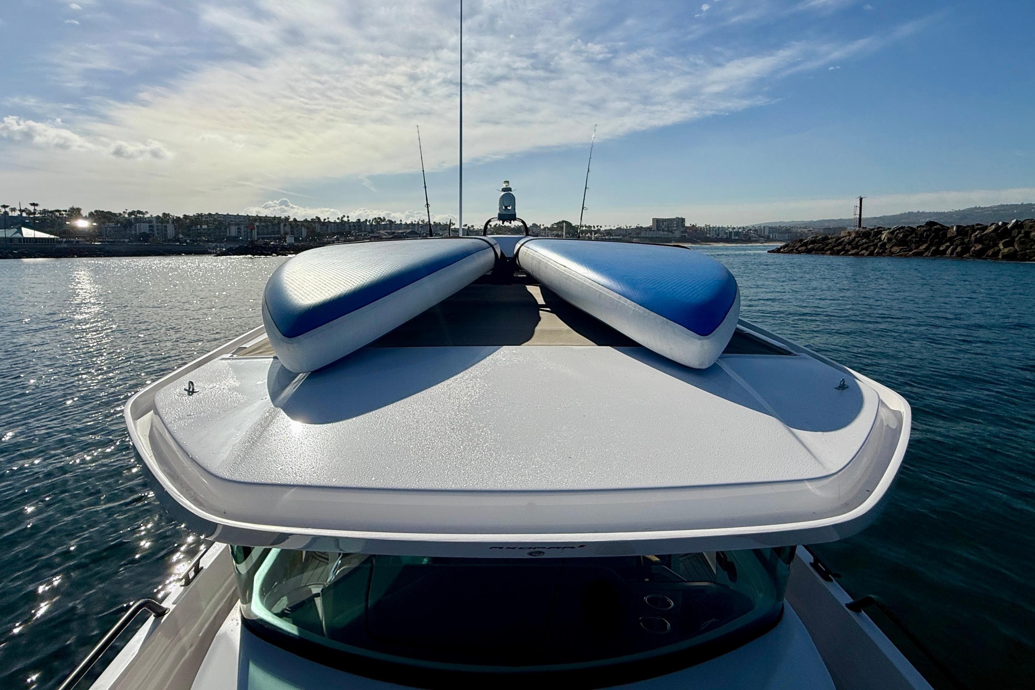 2021 Axopar Brabus 28 Cabin with paddleboards on roof, cruising in sunny coastal waters.