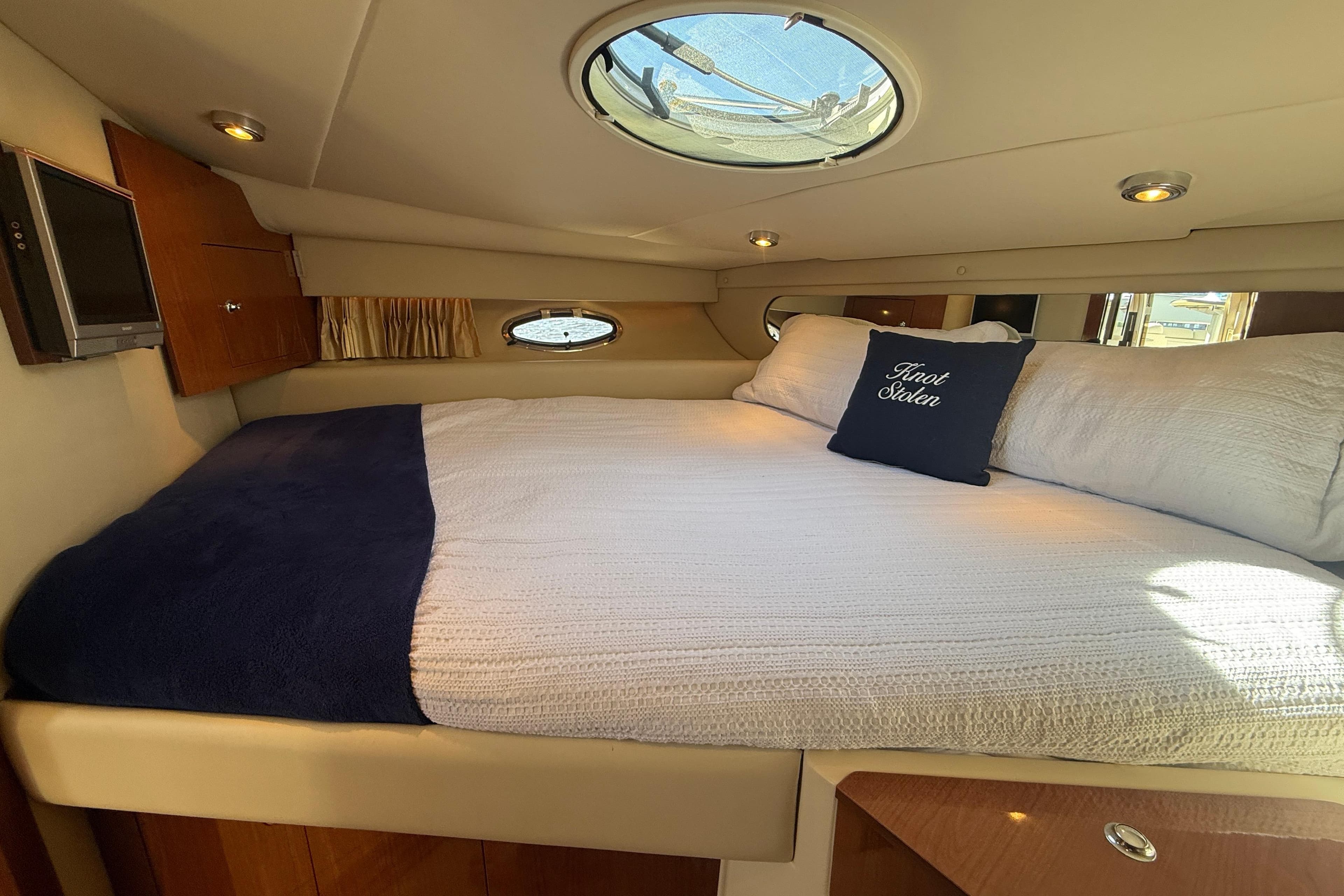 Luxurious cabin interior of 2006 Regal Commodore 3560 IO yacht with cozy bedding.