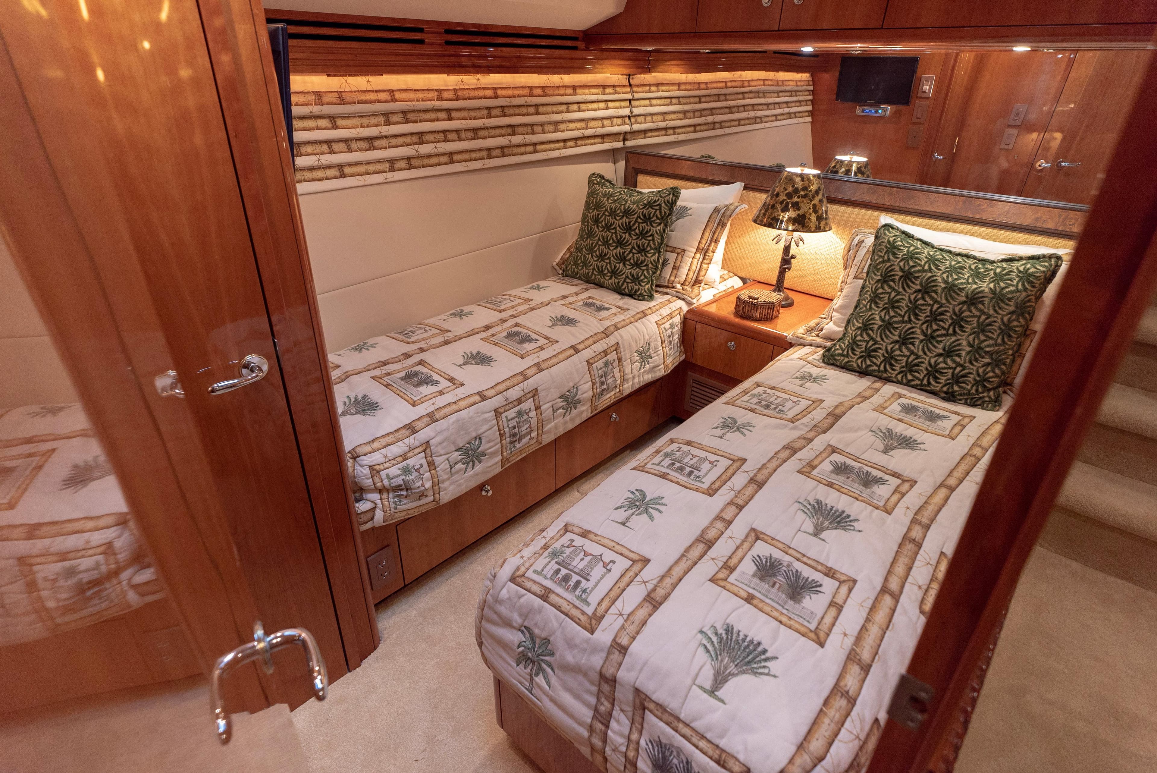 Luxurious twin bedroom in a 2003 Hatteras 70 Convertible yacht with elegant decor.