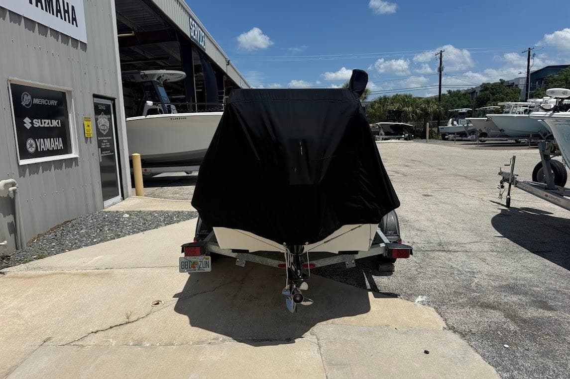 2024 Delta D18 boat covered on trailer at dealership, sunny day.