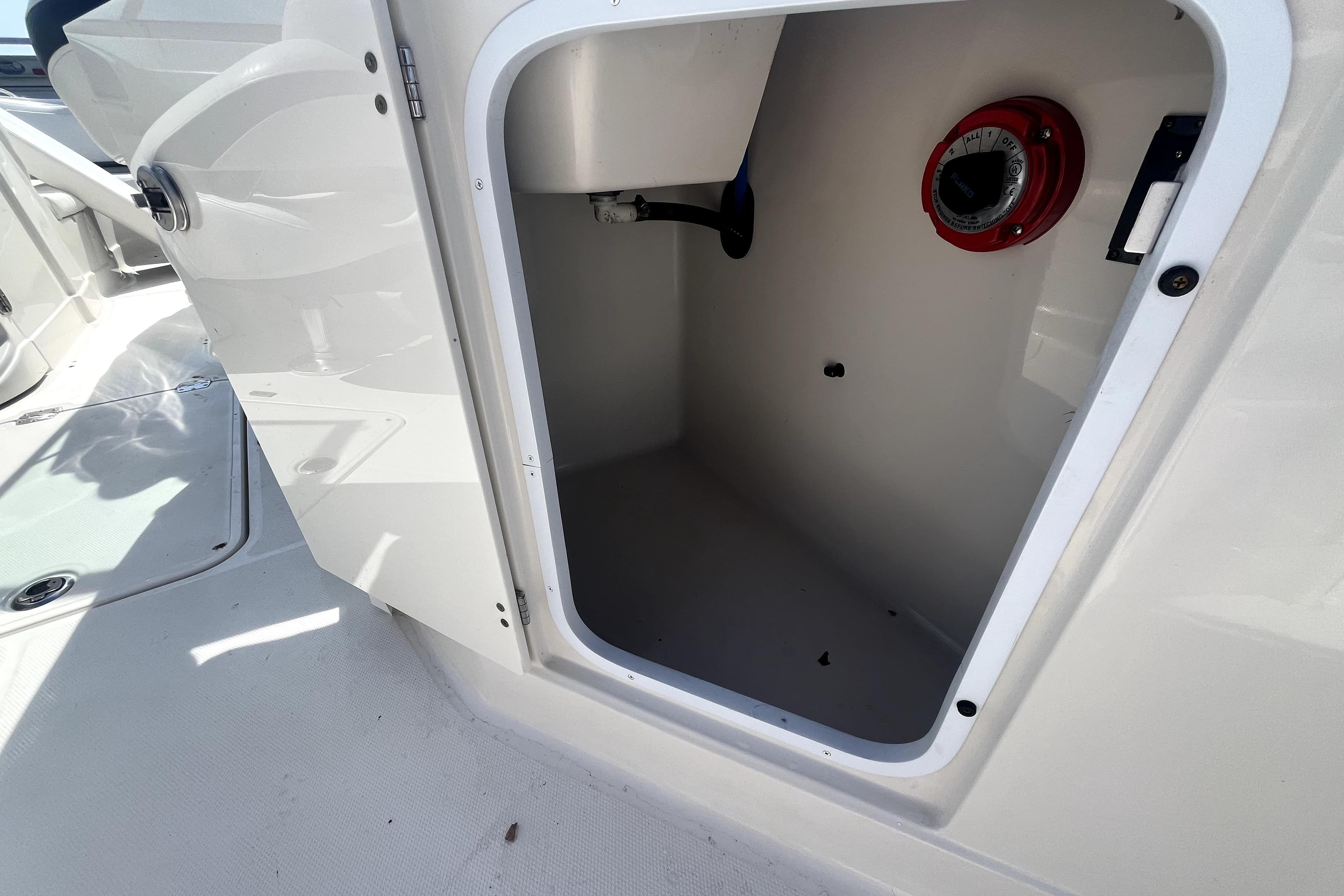Open storage compartment on a 2011 Monterey 254FSC boat, featuring a red dial.