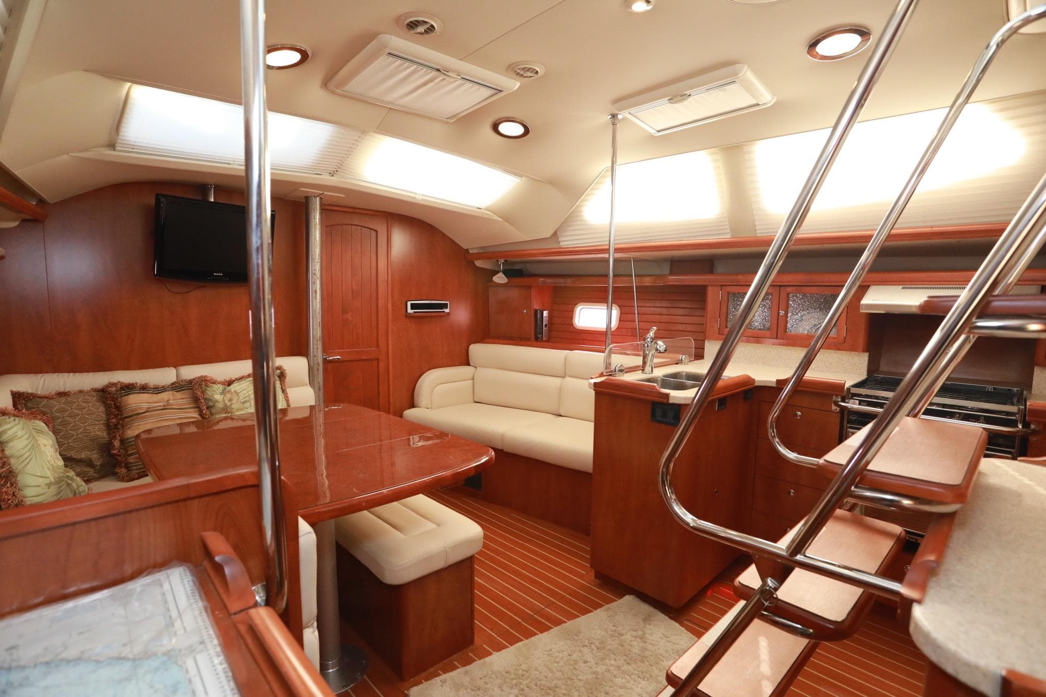 Luxurious interior of 2009 Hunter 45 Center Cockpit sailboat with wood finish and seating area.