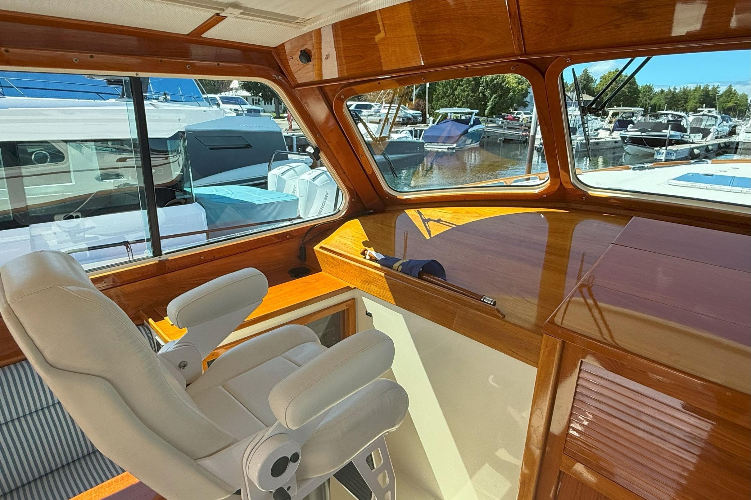 Interior of 2003 Hinckley Talaria 40 yacht with wooden finish and white captain's chair.