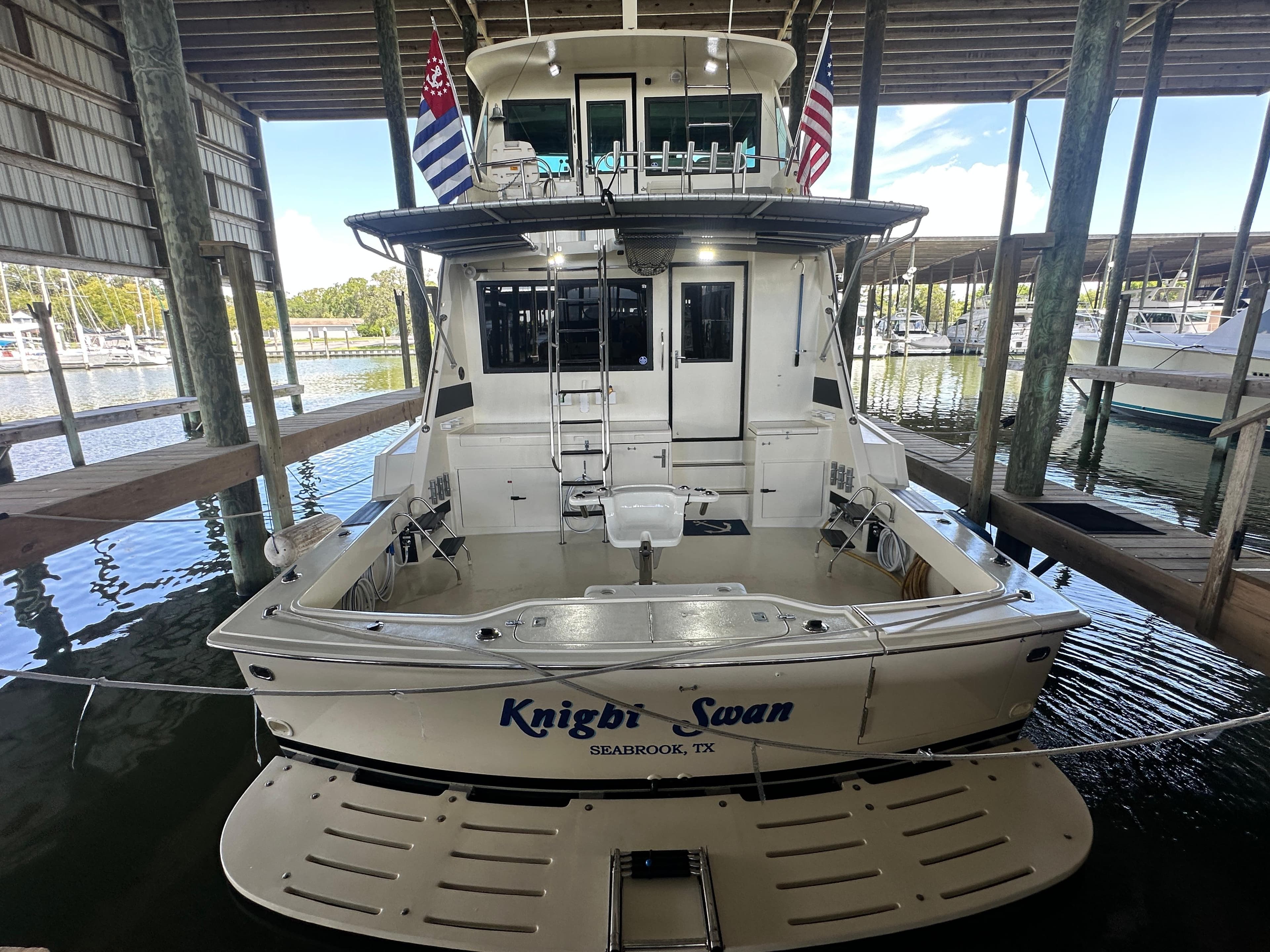 1988 Hatteras Enclosed Bridge Sportfish docked in a marina, rear view.