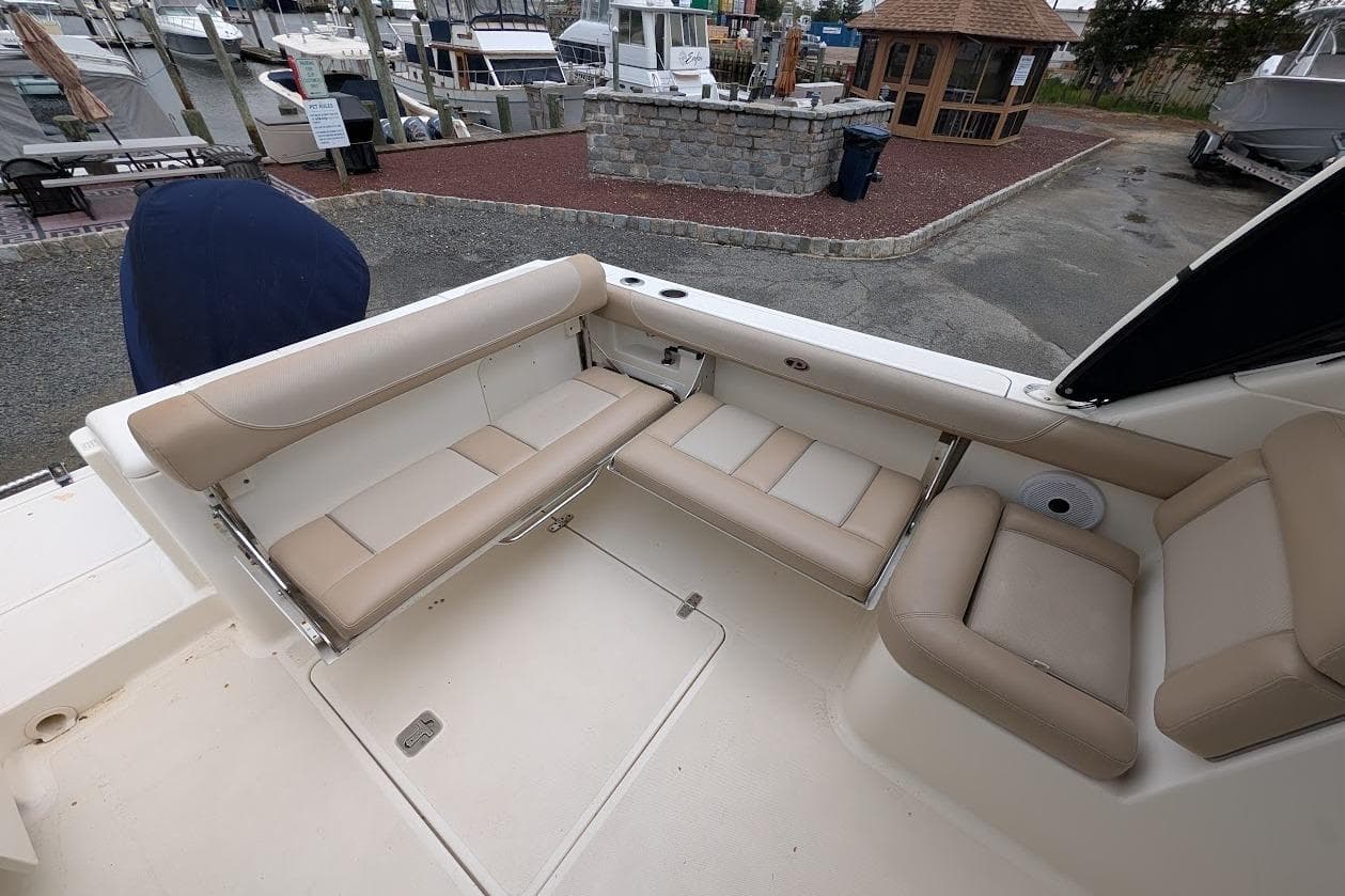 2011 Pursuit DC 265 Dual Console boat interior with beige seating, docked at marina.