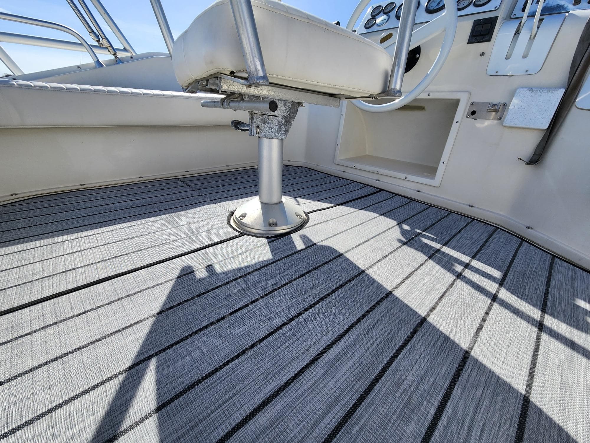 1990 Mainship Mediterranean boat interior with striped flooring and steering area.