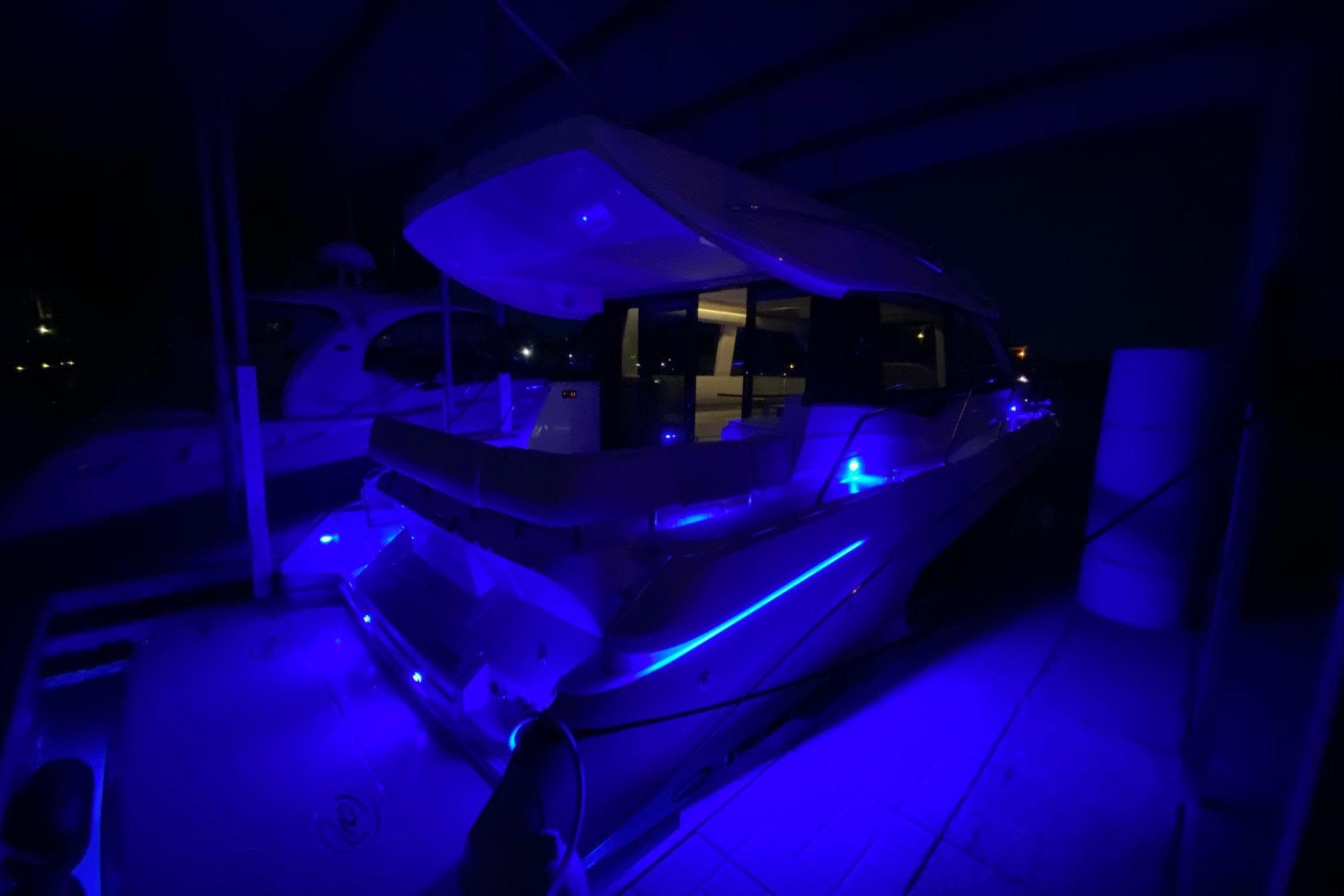 2018 Regal 42 Grande Coupe yacht illuminated with blue lights at night.