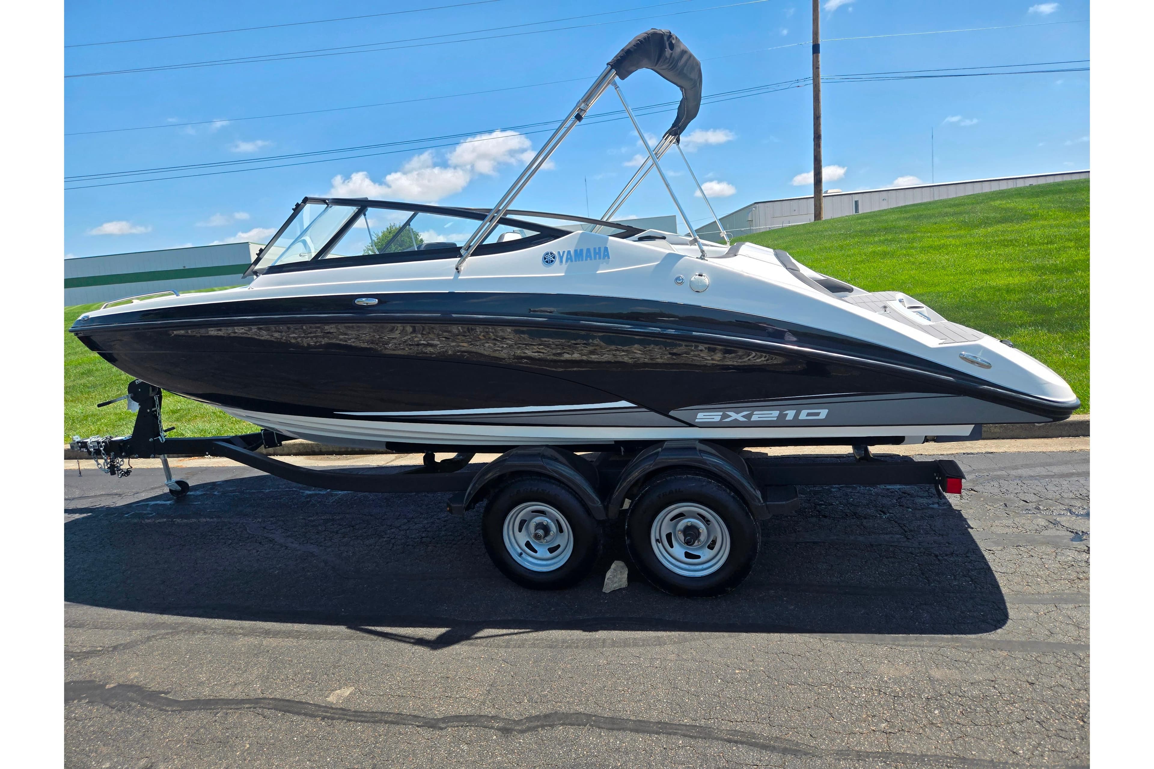 2019 Yamaha Boats SX210 on trailer, sleek black and white design, sunny day background.