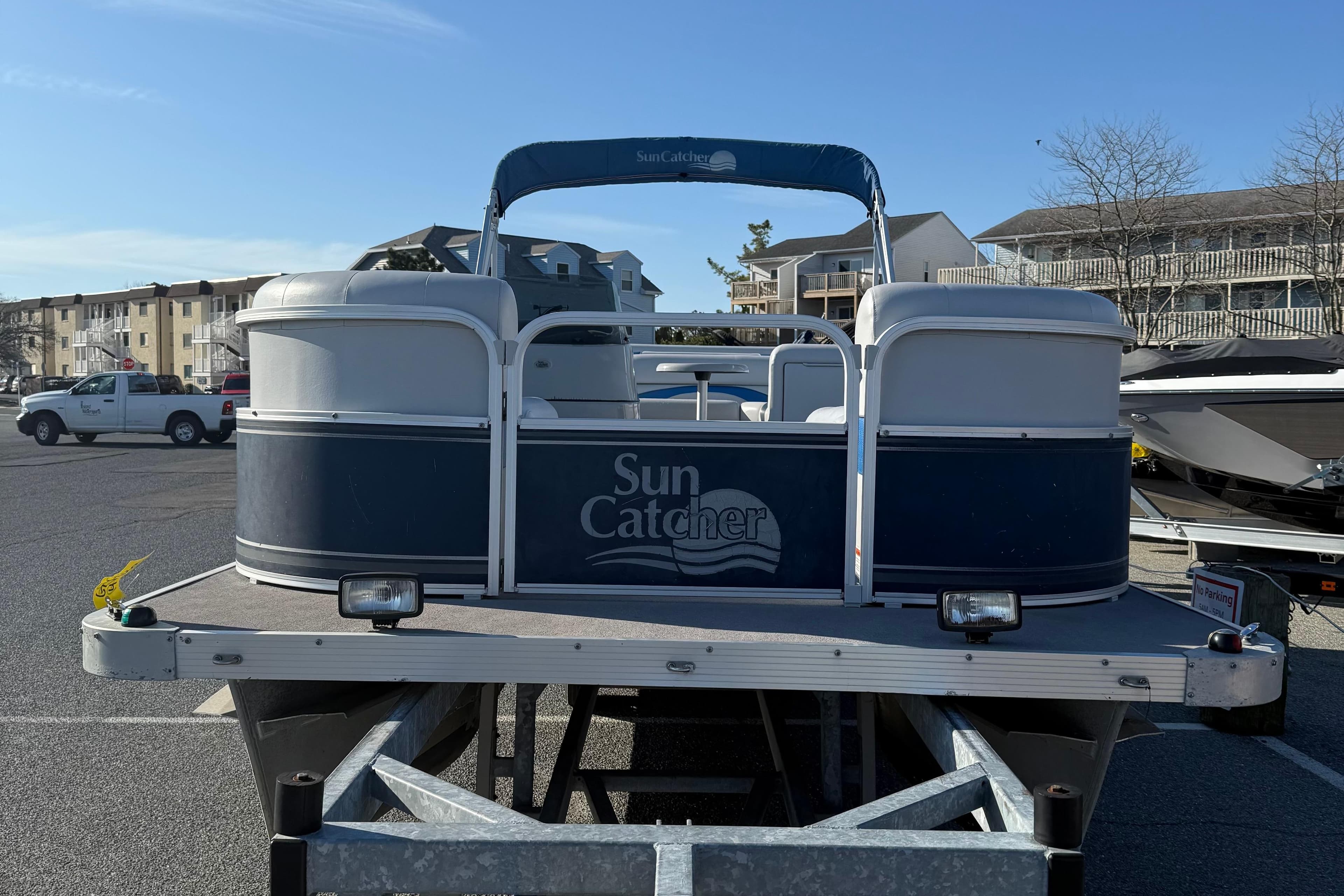 2012 SunCatcher LV 228 Cruise pontoon boat on trailer in parking lot.