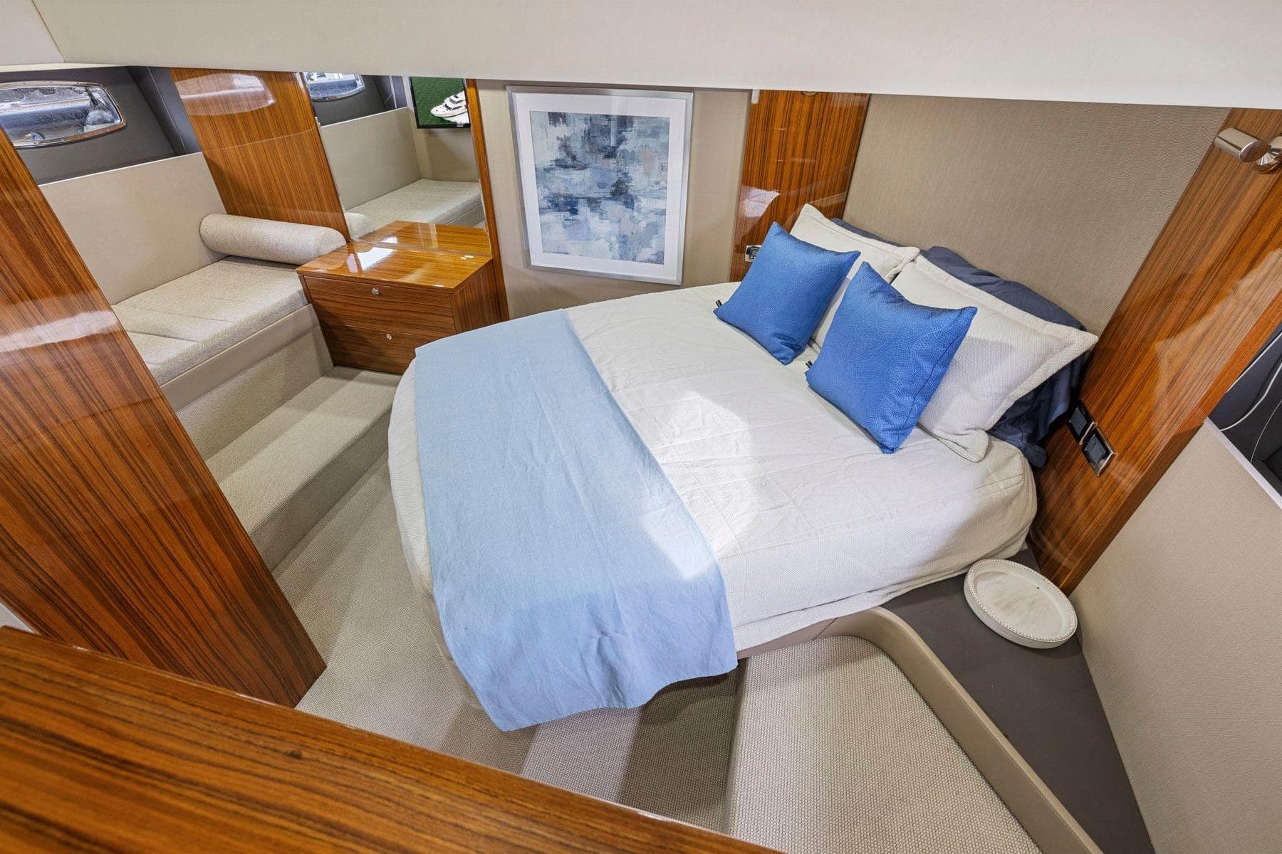 Luxurious 2014 Maritimo M50 yacht bedroom with elegant wood finishes and blue accents.