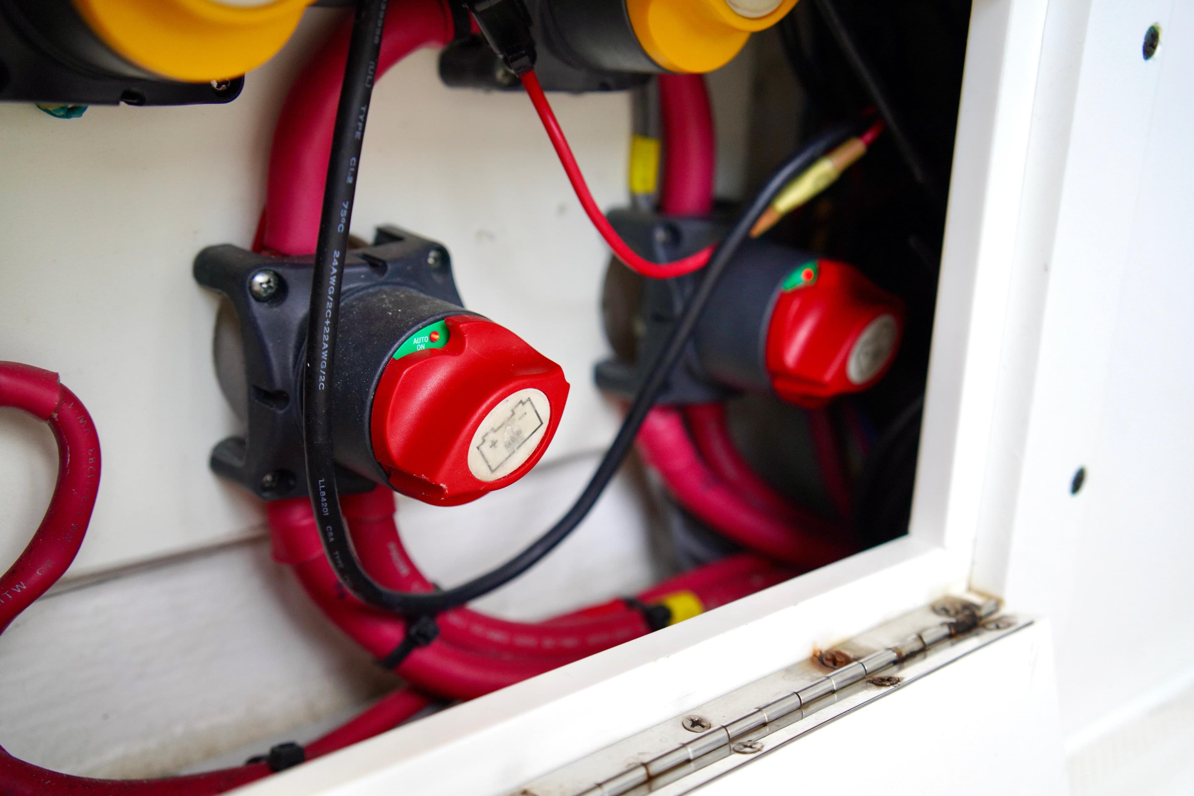 Electrical system of 2019 Invincible 36 Open Fisherman boat with red cables and switches.