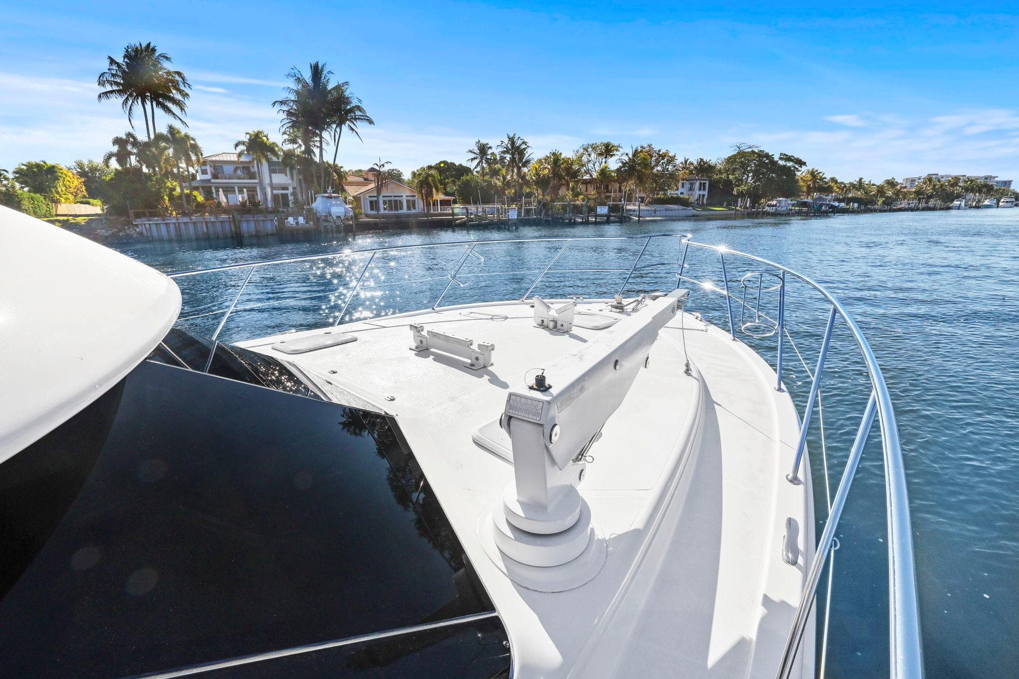 2016 Riviera 43 Open Flybridge yacht cruising near waterfront homes.
