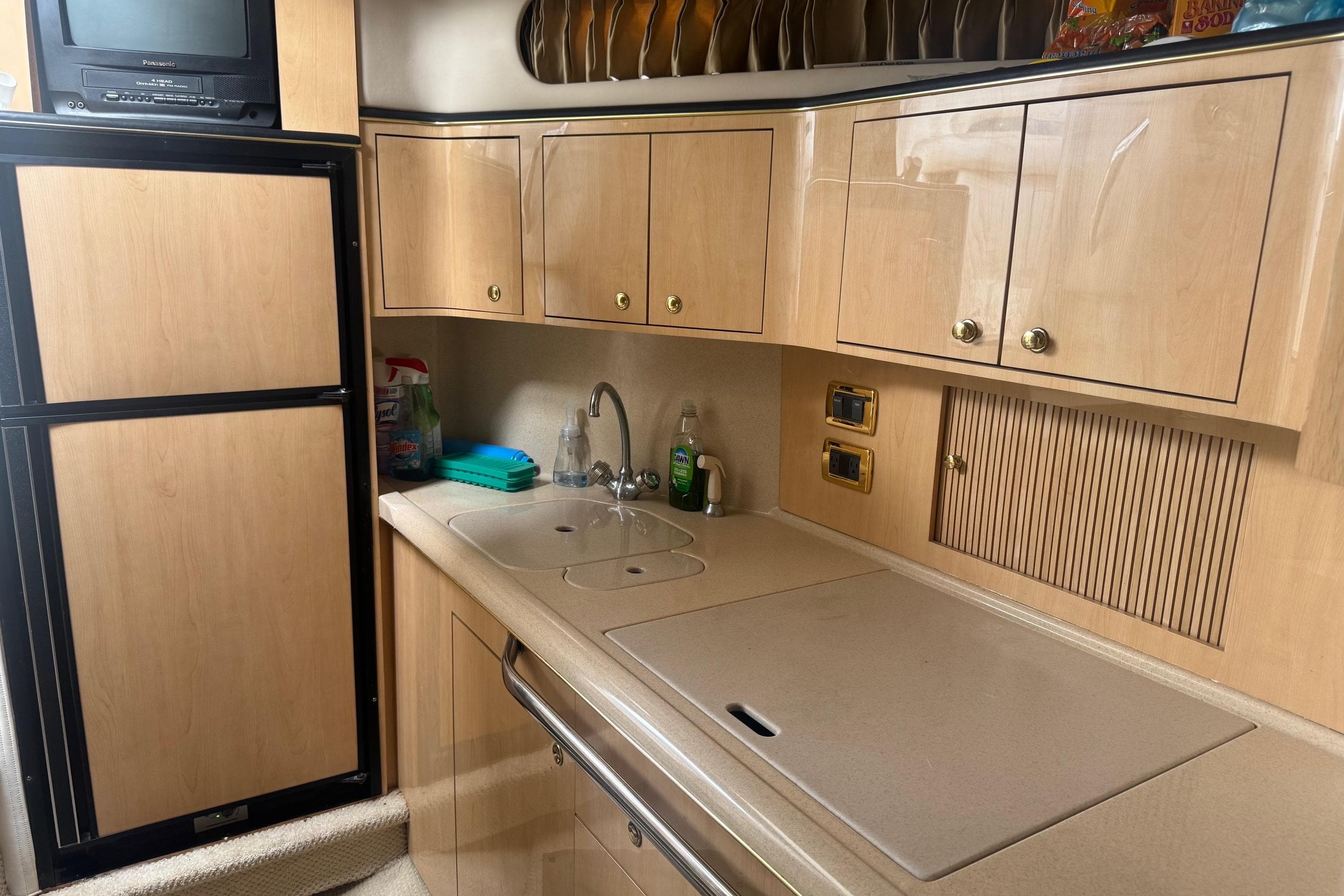 2001 Sea Ray 410 Sundancer kitchen with wooden cabinets, sink, and appliances.