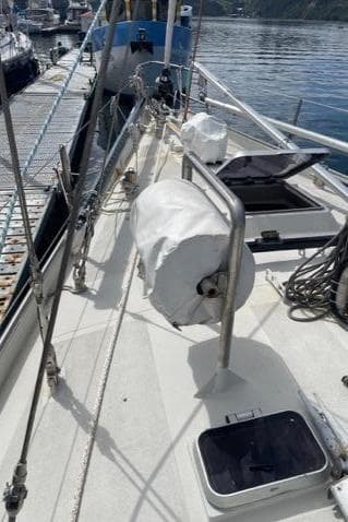 1983 Schooner Damien II sailboat deck with ropes and equipment, docked at a marina.