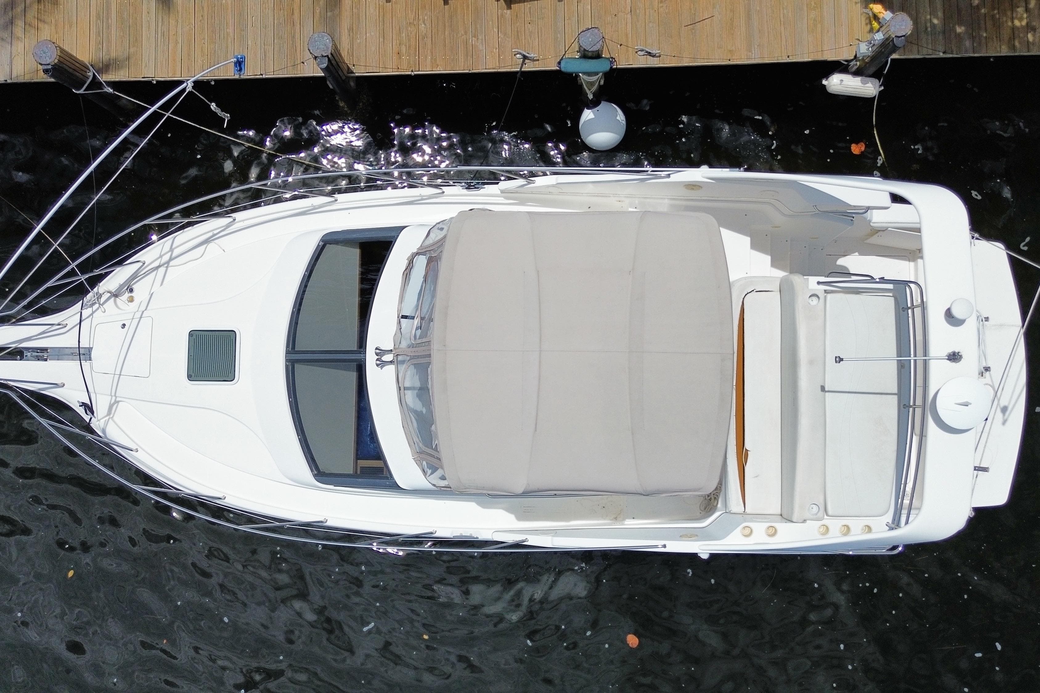 Overhead view of a 2002 Silverton 330 Sport Bridge yacht docked at a wooden pier.