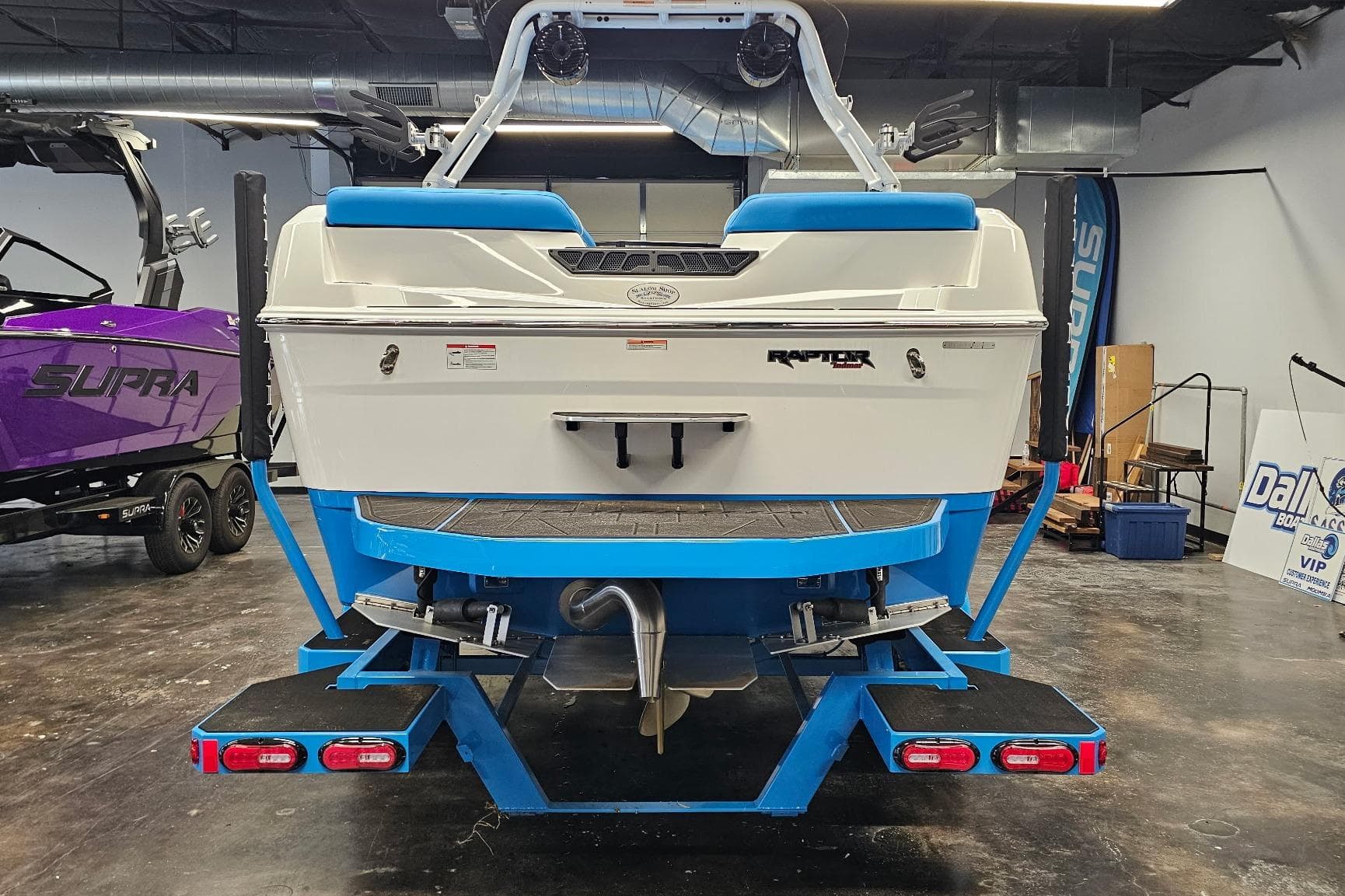2026 Moomba Max boat in showroom, featuring Raptor engine and vibrant blue accents.
