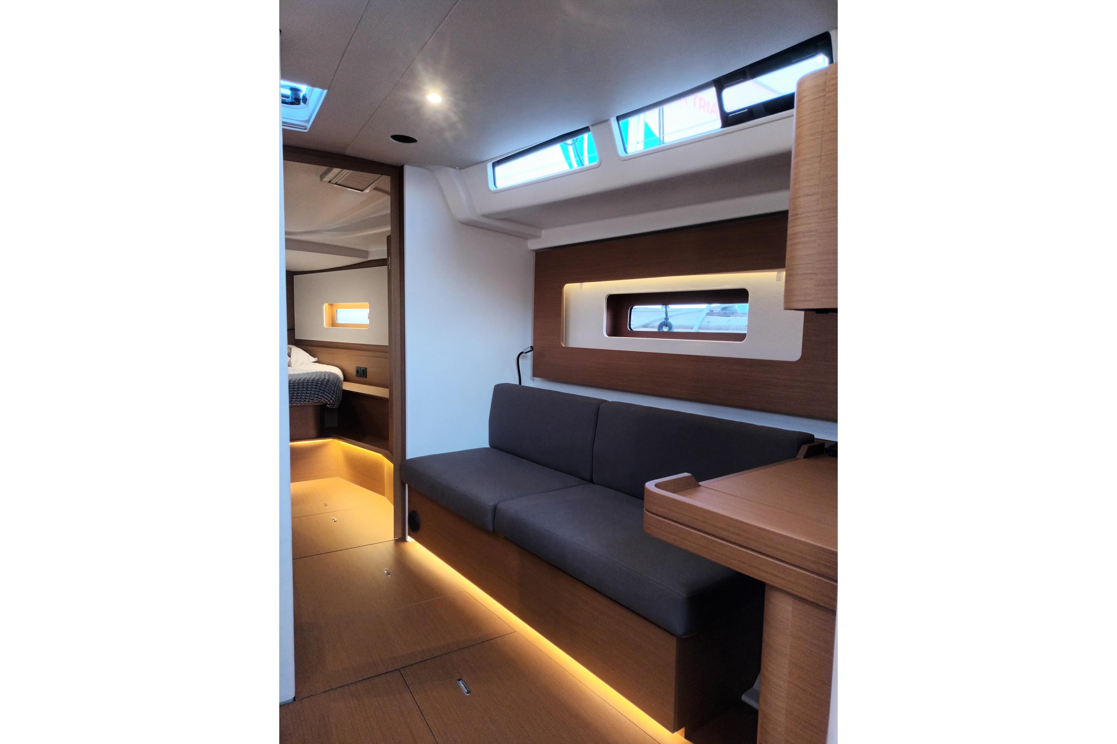 Luxurious interior of 2025 Beneteau First 44 yacht, featuring modern seating and ambient lighting.