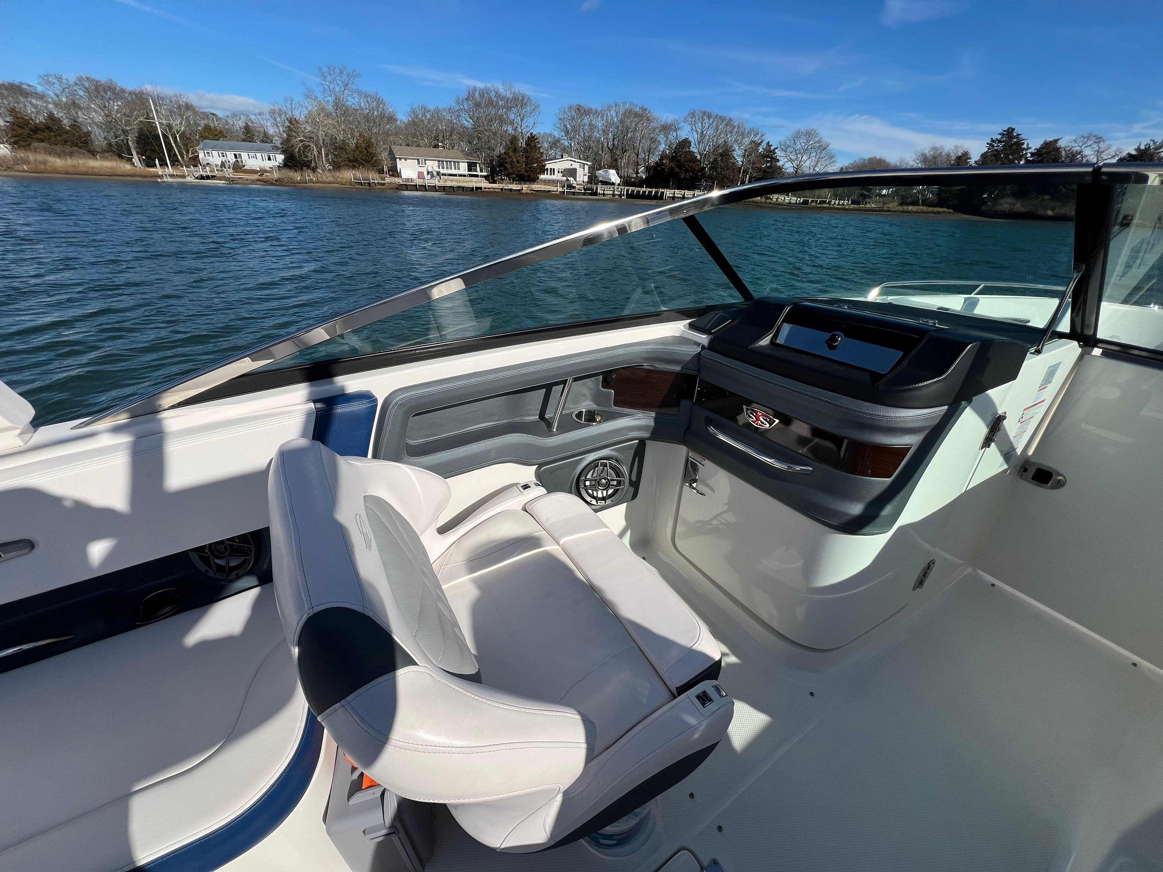 2021 Chaparral 307 SSX boat interior with helm and seating, on a sunny day.