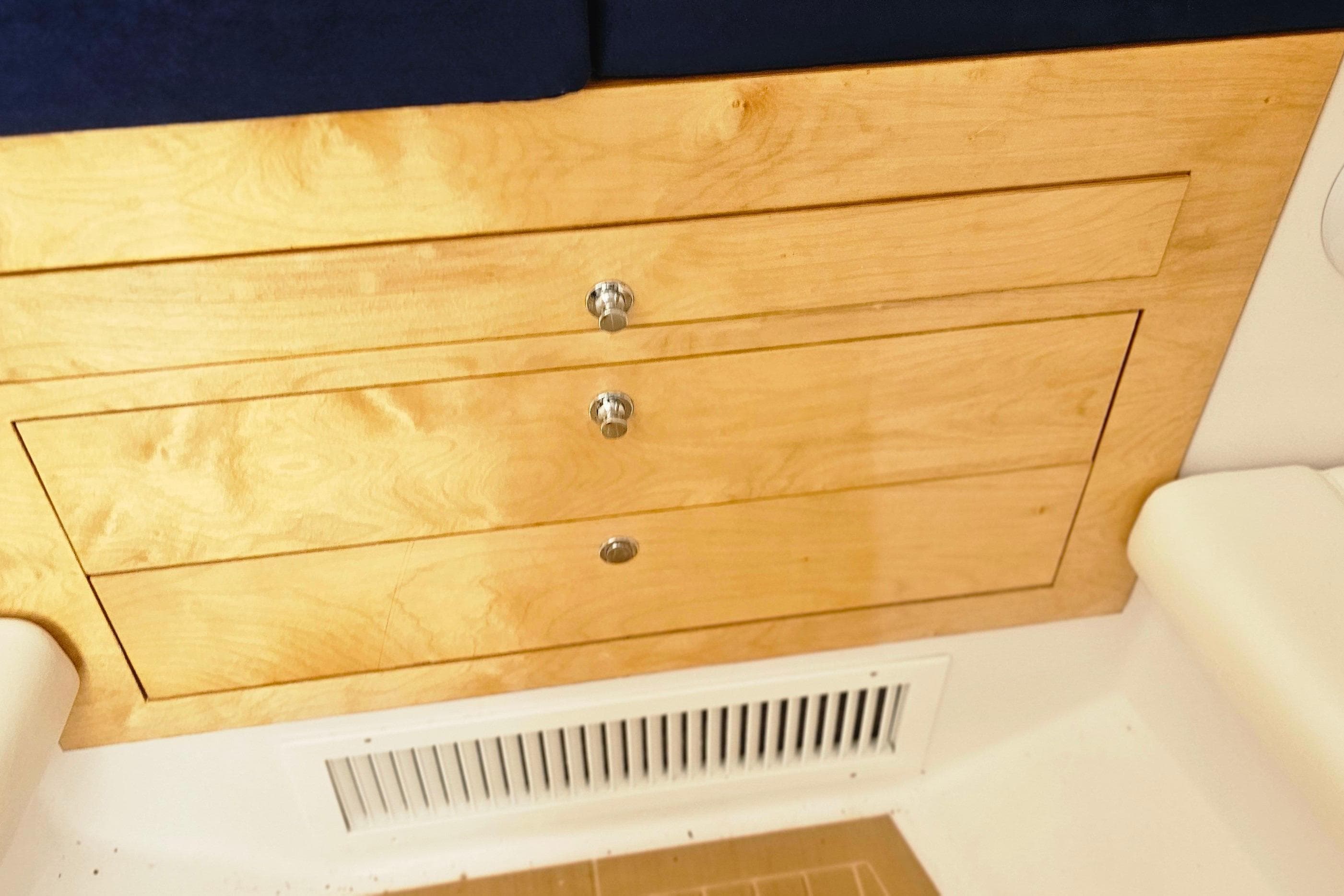 Wooden drawers inside a 2004 Donzi 38 ZSF boat, featuring sleek metal handles.