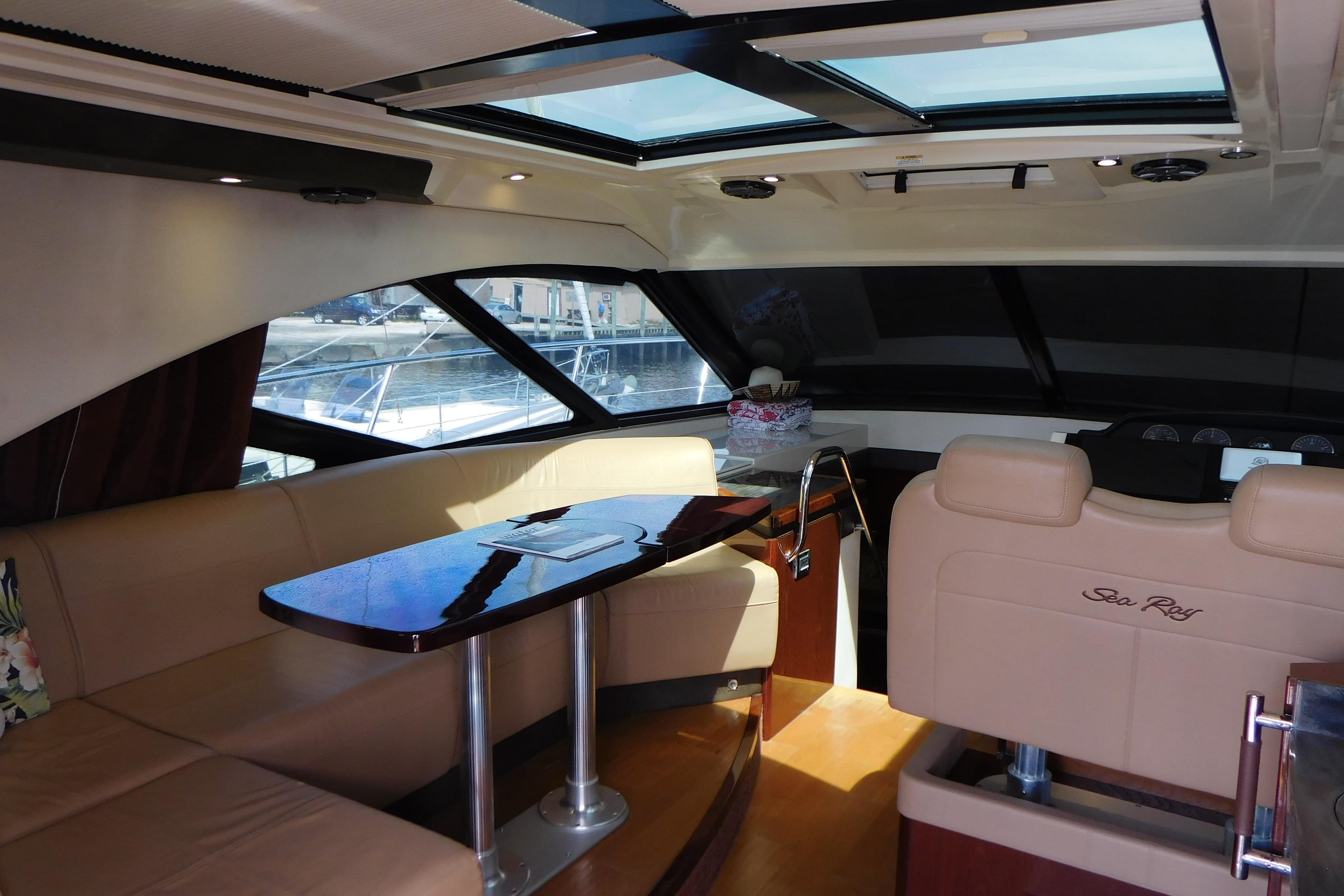Luxurious interior of 2013 Sea Ray 510 Sundancer yacht with plush seating and elegant table.