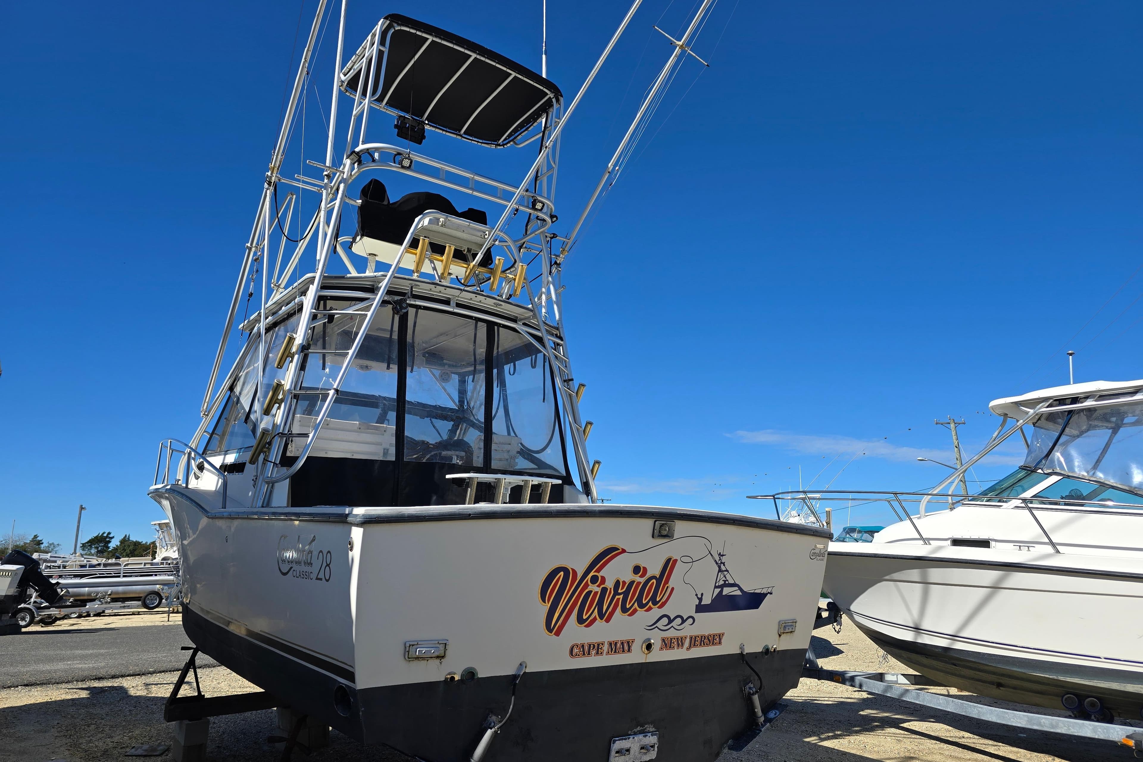 2002 Carolina Classic 28 Express boat on trailer under clear blue sky.