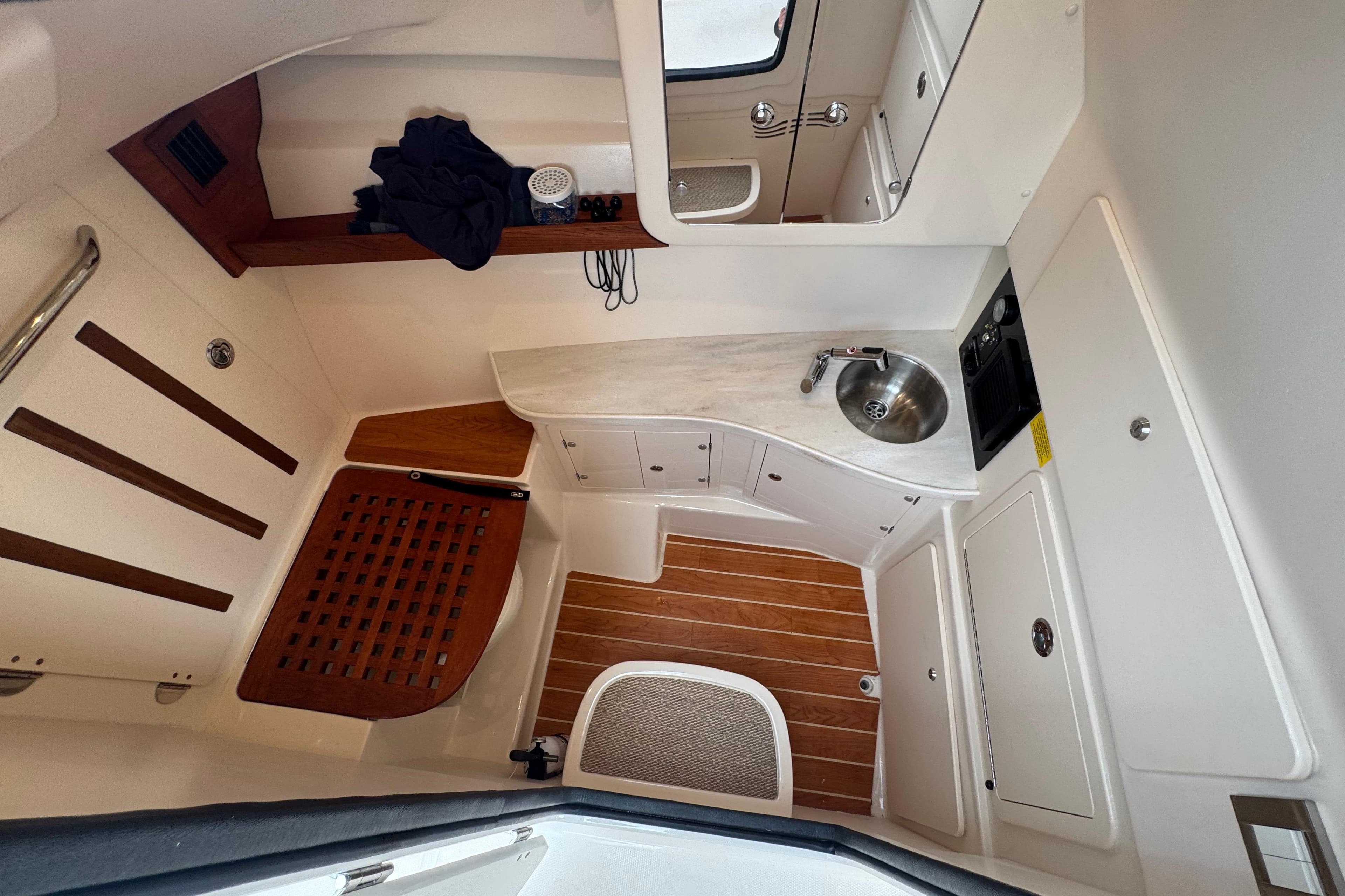 2024 Grady-White Freedom 335 cabin interior with sink, wooden flooring, and storage.