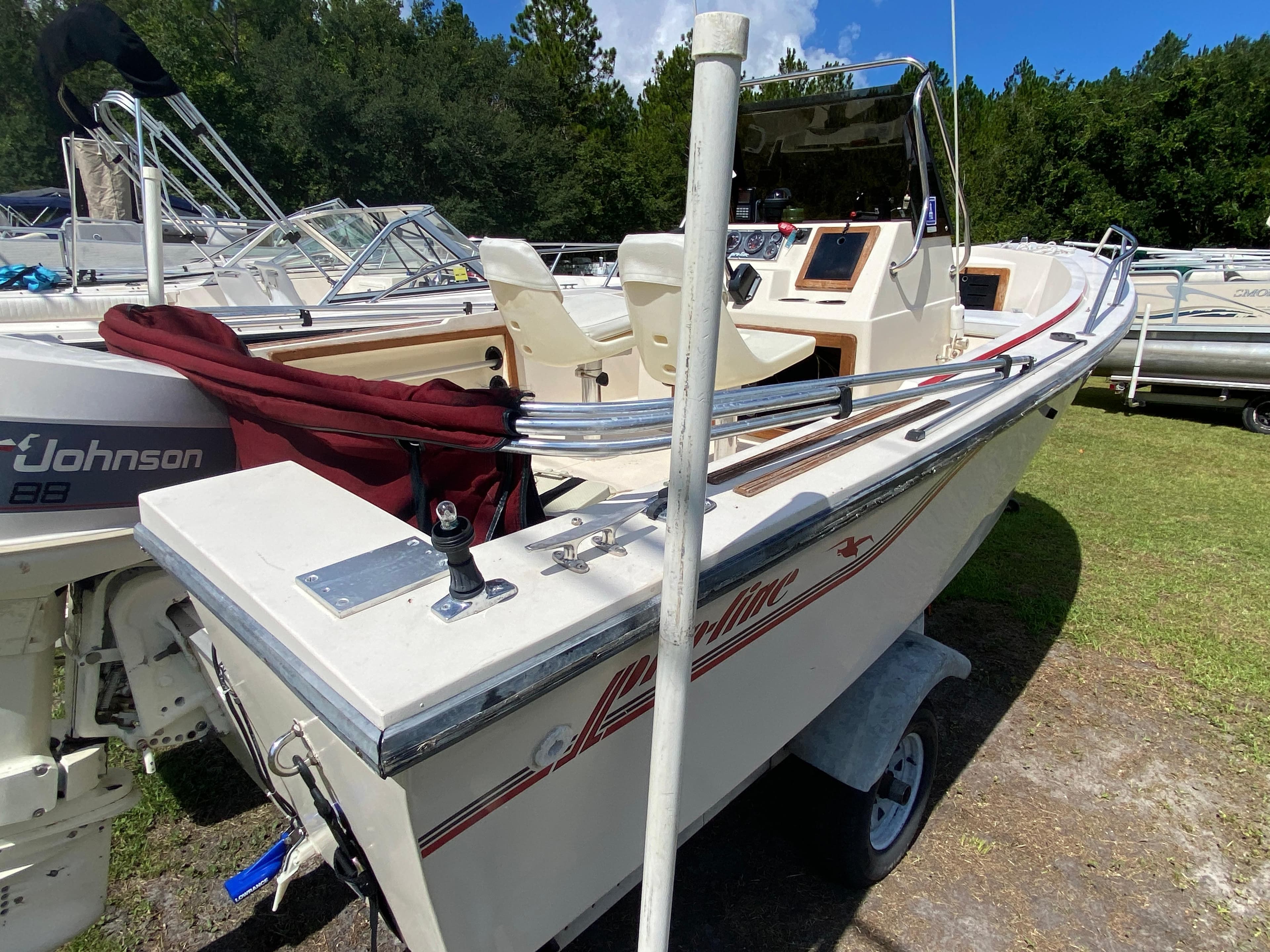 1988 Pro-Line 17cc boat with Johnson 88 outboard motor, parked on grass.