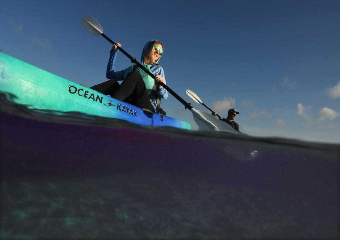 Two people kayaking on an Ocean Kayak Malibu 9.5, 2023 model, in clear waters.