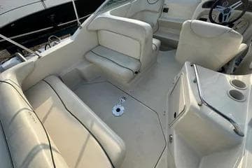 2000 Sea Ray 240 Sundancer boat interior with white seating and steering wheel.