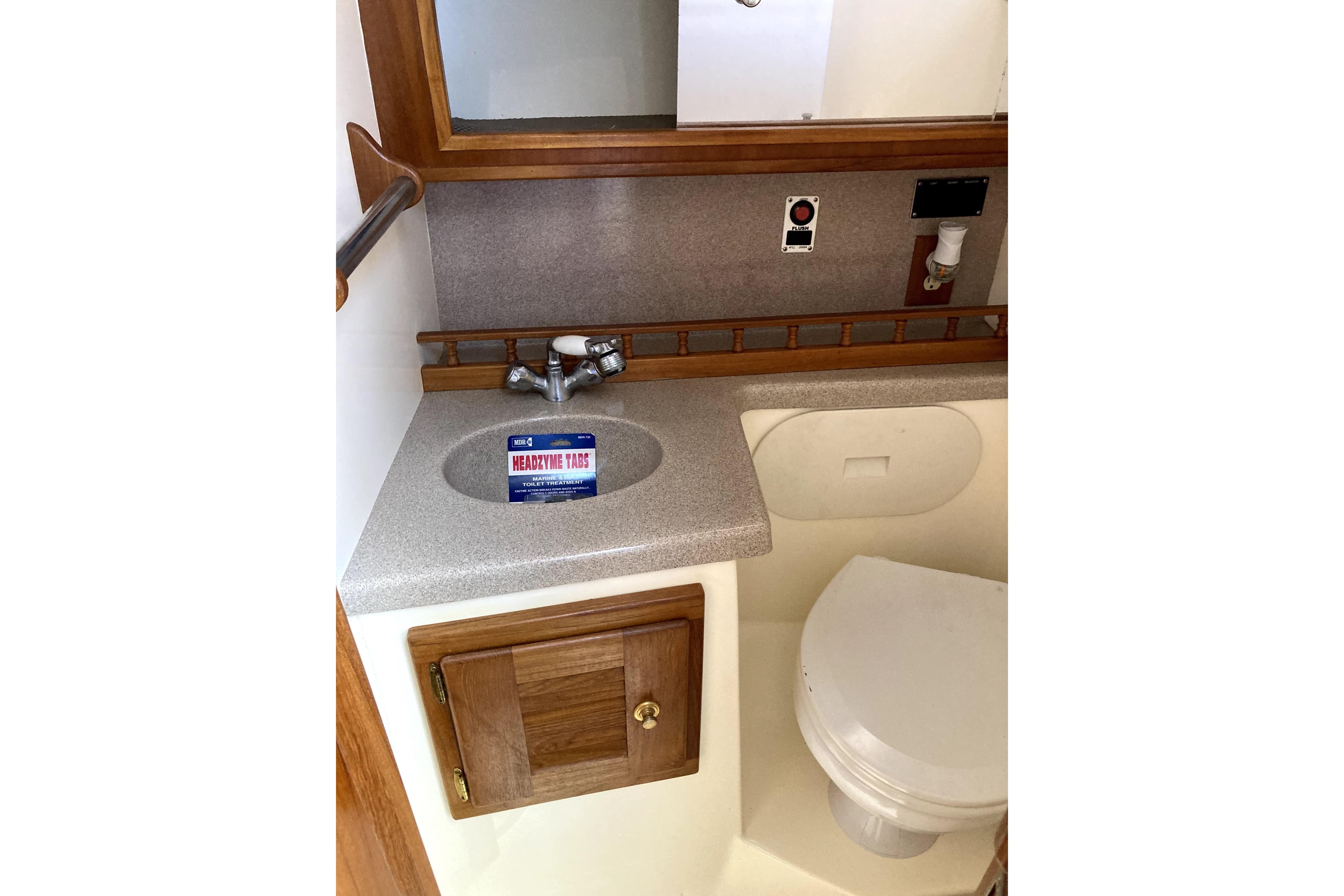 2002 Albemarle 28 Express boat bathroom with sink, mirror, and toilet.