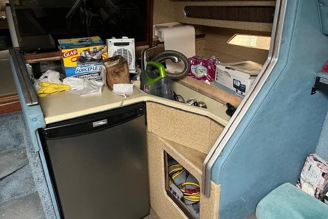 1981 Sea Ray Sundancer 310 interior with kitchenette, mini fridge, and storage compartments.
