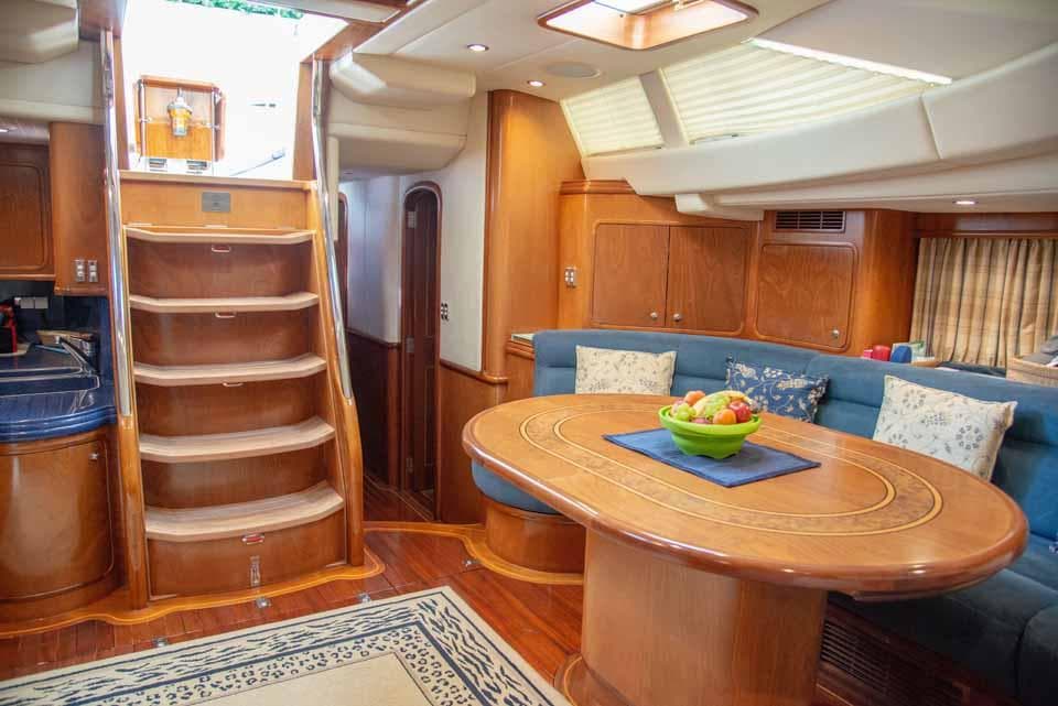 Luxurious interior of 2002 Southern Ocean Dixon 65 yacht with elegant wood finishes and cozy seating.