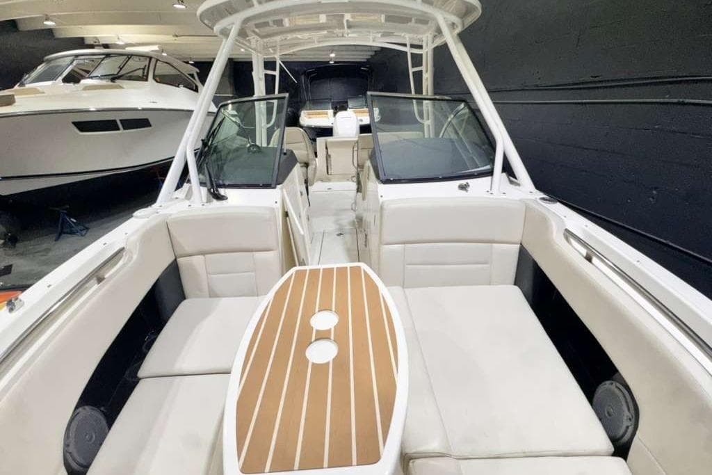 2018 Boston Whaler 230 Vantage boat interior with seating and table in a showroom.