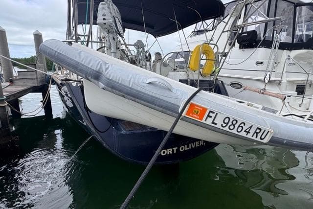 1996 Beneteau 50 sailboat docked, featuring inflatable dinghy and registration FL 9864 RU.