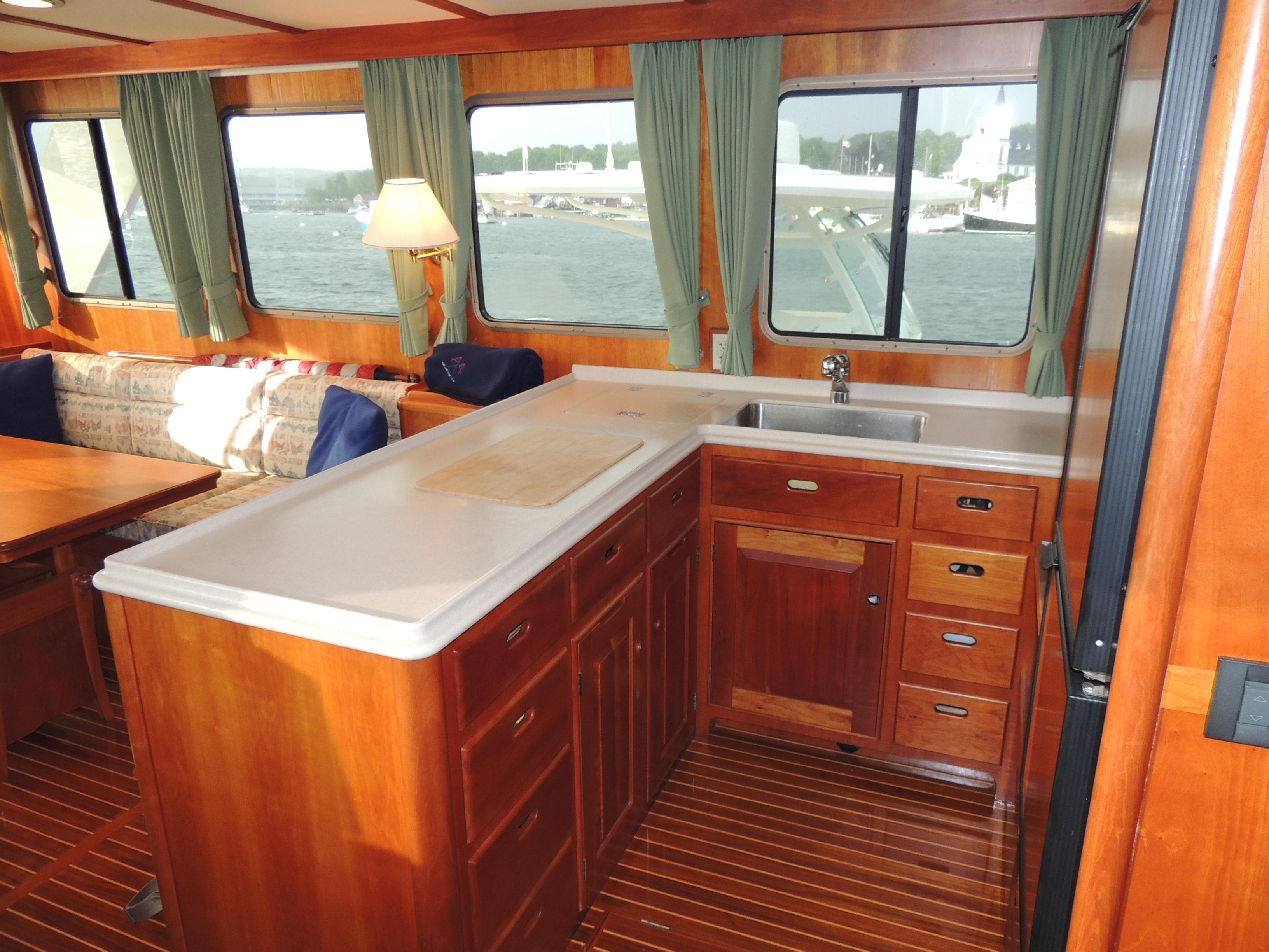 Interior of 1999 Lyman-Morse pilothouse with wooden cabinetry and large windows.