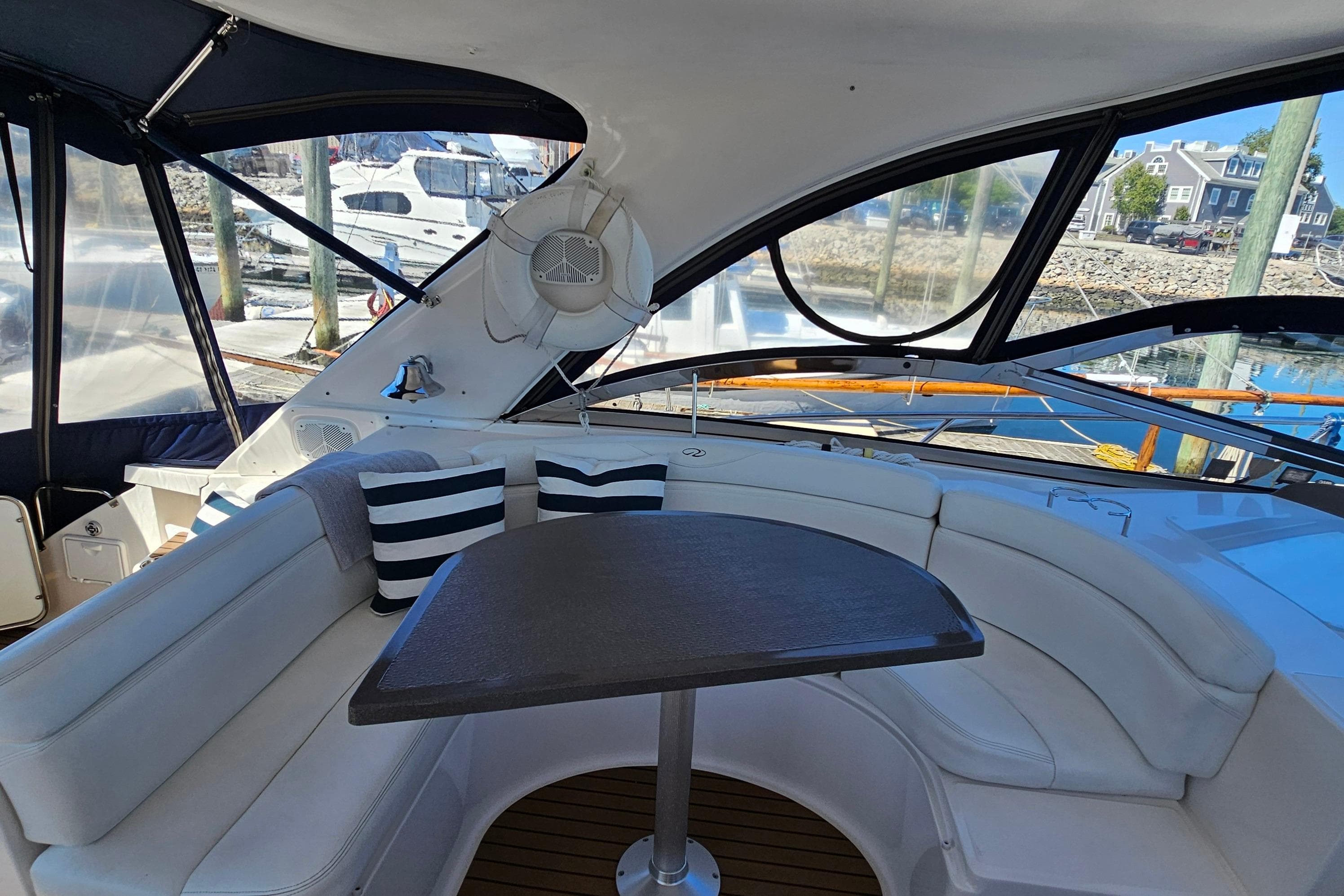 2005 Regal Commodore 4260 yacht interior with curved seating and table, docked at marina.