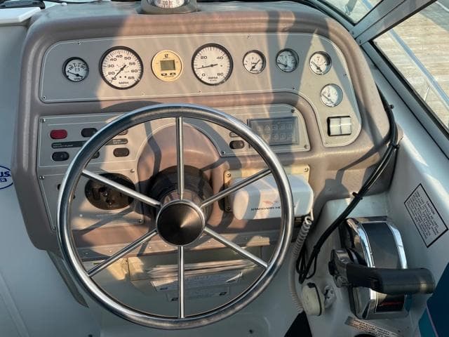 1994 Rinker Fiesta Vee 265 boat dashboard with steering wheel and gauges.
