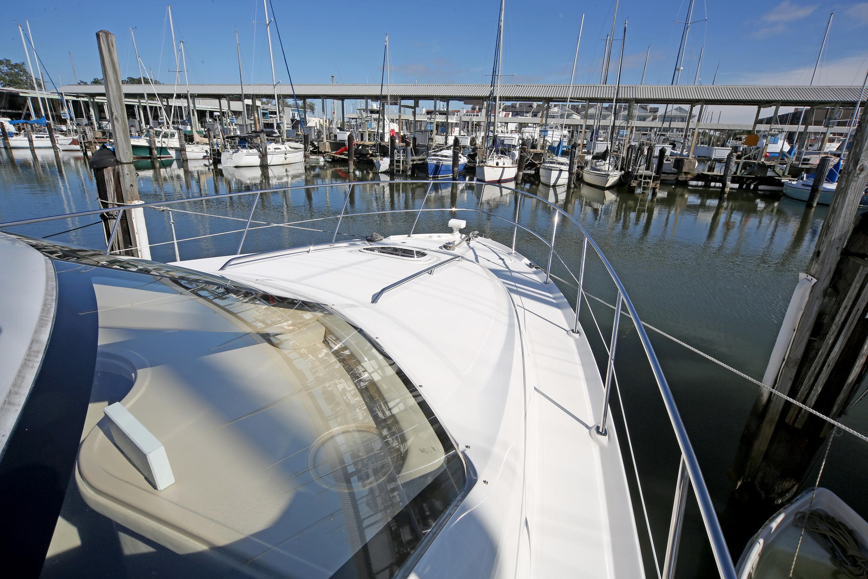 2007 Sea Ray 44 Sedan Bridge yacht docked in a marina with sailboats.